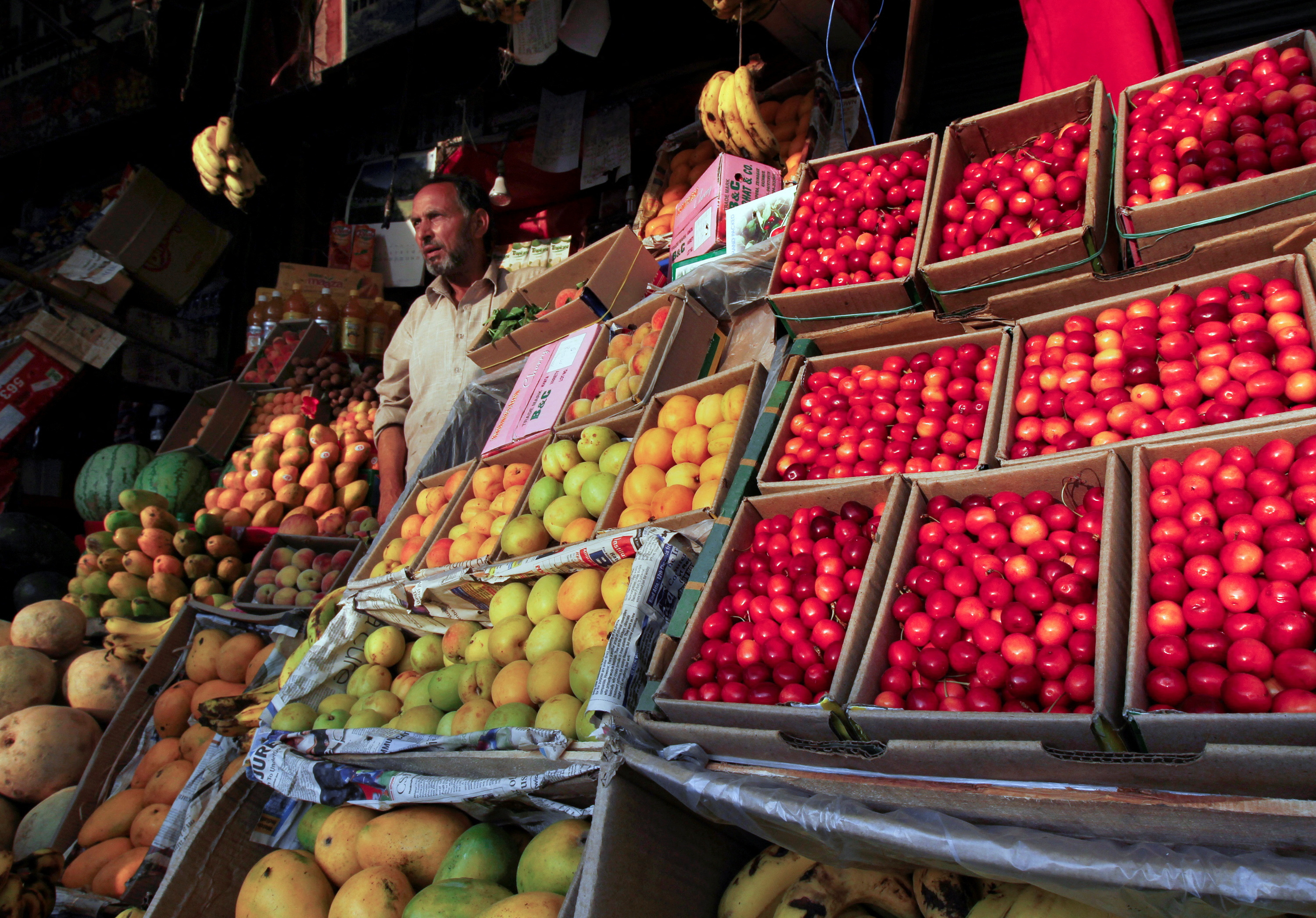 A man sells fruit from his stall along a road in Srinagar