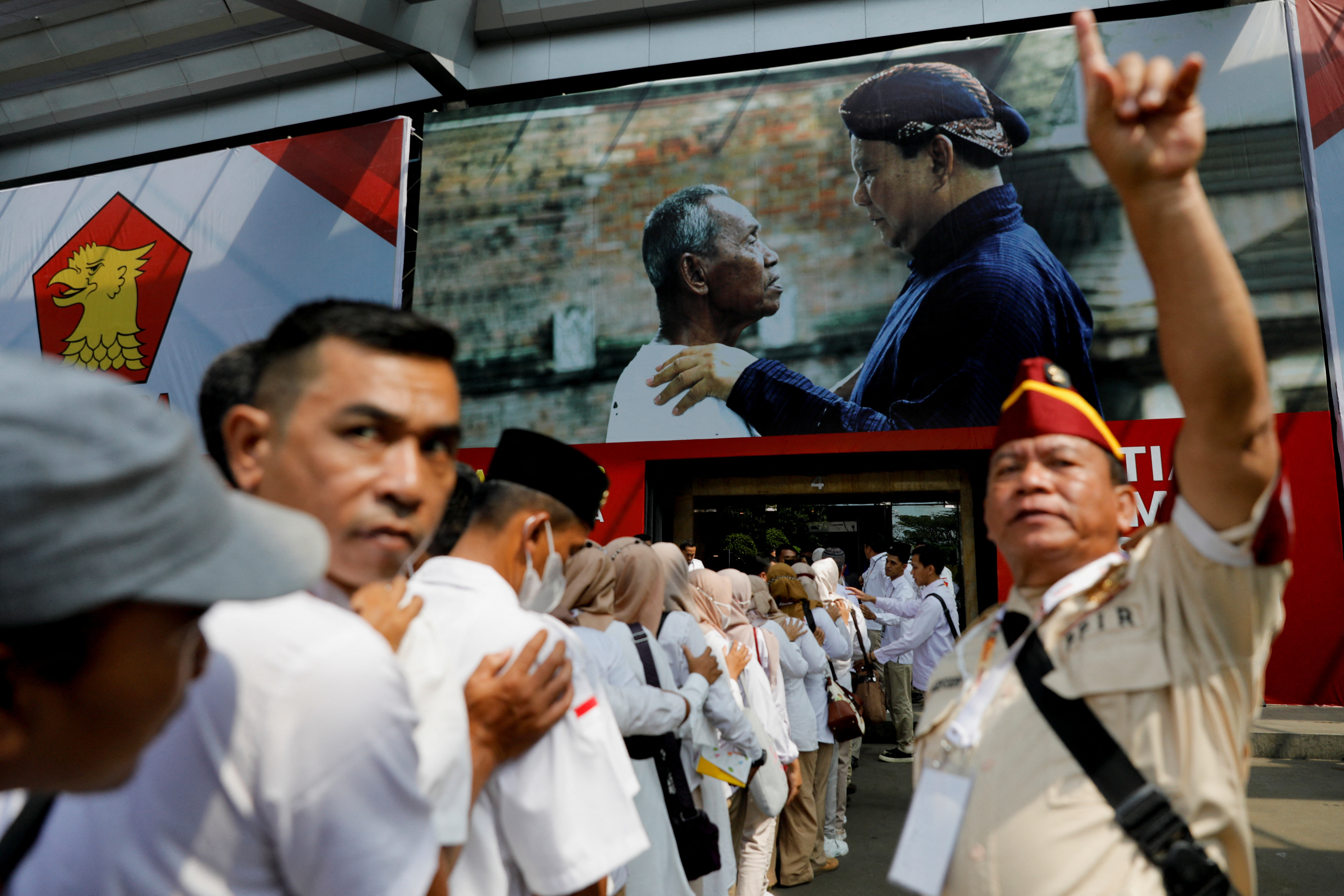 Gerindra Party's members queue to enter the venue of the national meeting of its leaders as a picture of Prabowo Subianto is seen in the background, in Bogor