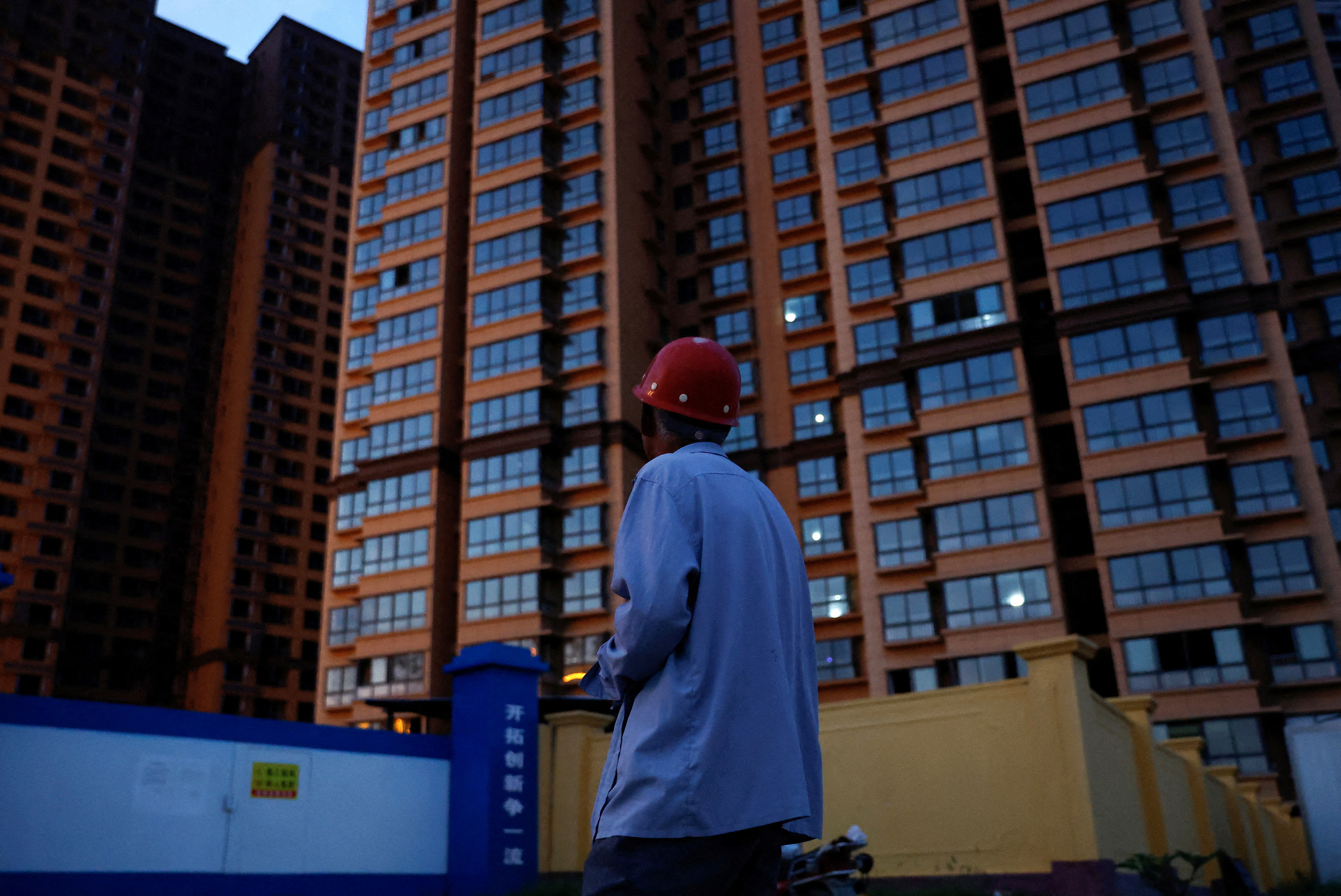 Zhao Youming, 60, looks at an unfinished residential building where he bought an apartment in Tongchuan
