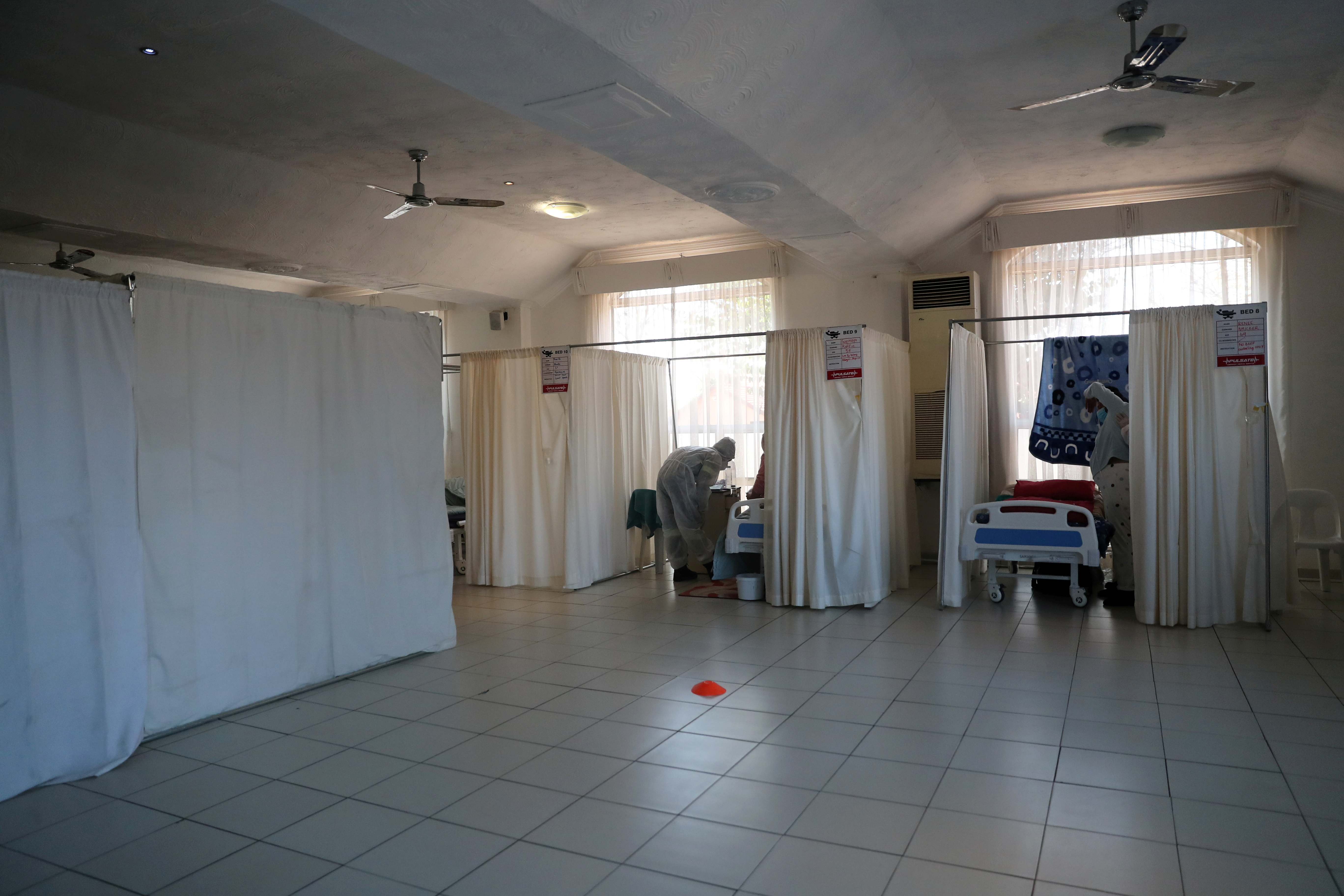 Profissionais de saúde assistem pacientes em tratamento em um hospital improvisado administrado pela organização de caridade The Gift of the Givers, durante o surto da doença coronavírus (COVID-19) em Joanesburgo, África do Sul, 11 de julho de 2021. REUTERS / Sumaya Hisham