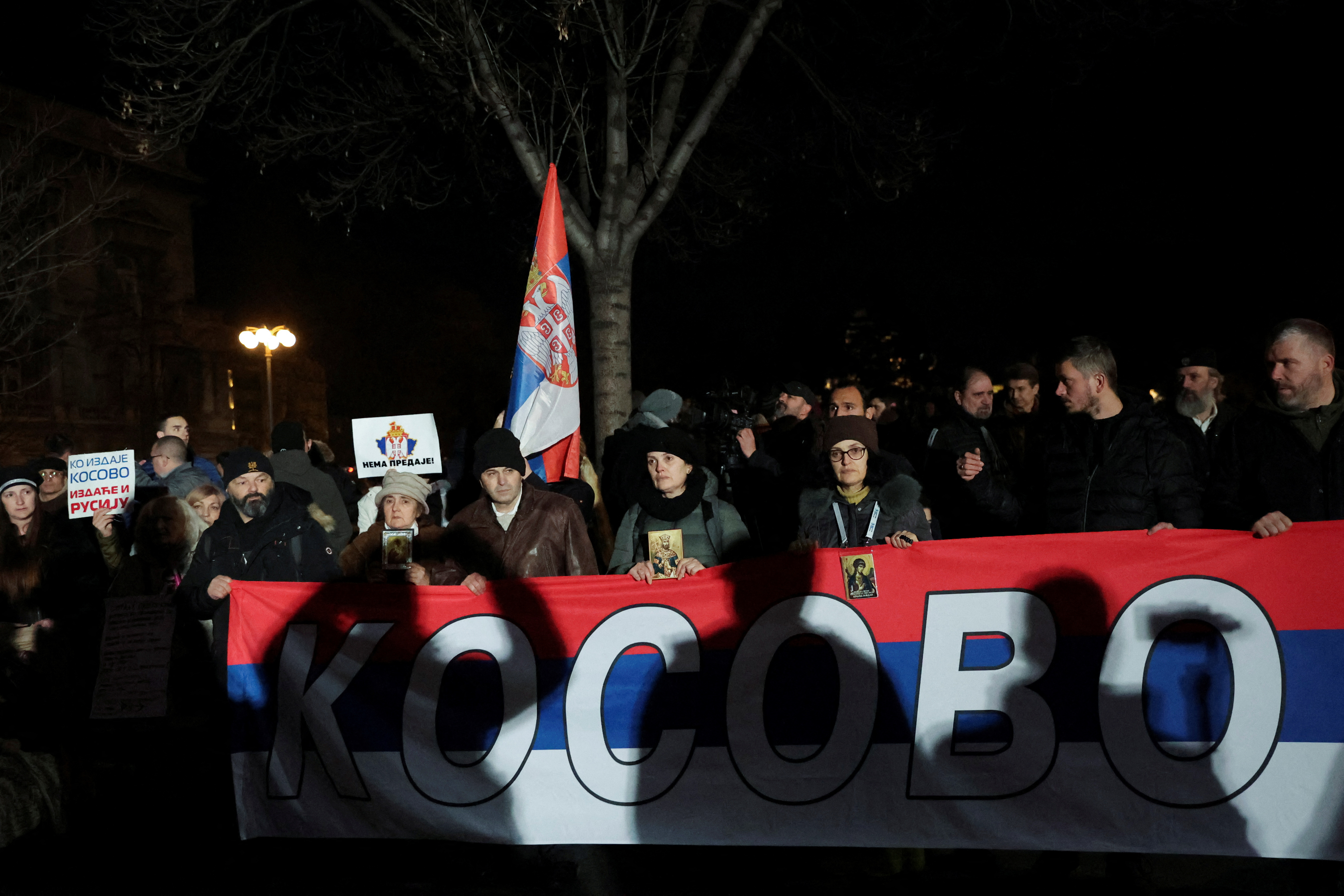 People hold a Serbian flag reading "Kosovo" during a protest against the Serbian authorities and French-German plan for the resolution of Kosovo