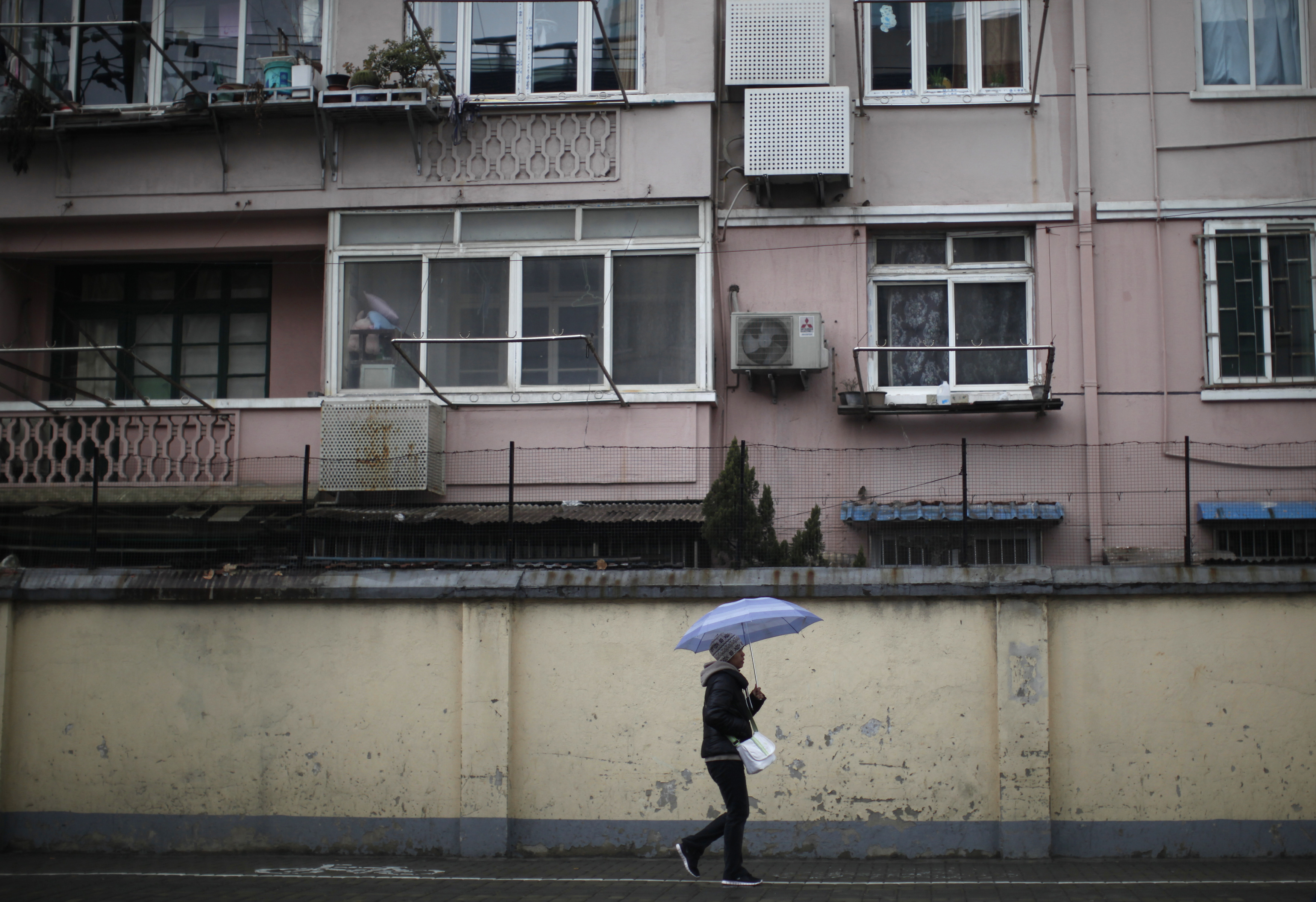 A man walks at a residential area in downtown Shanghai January 28, 2011. REUTERS/Carlos Barria