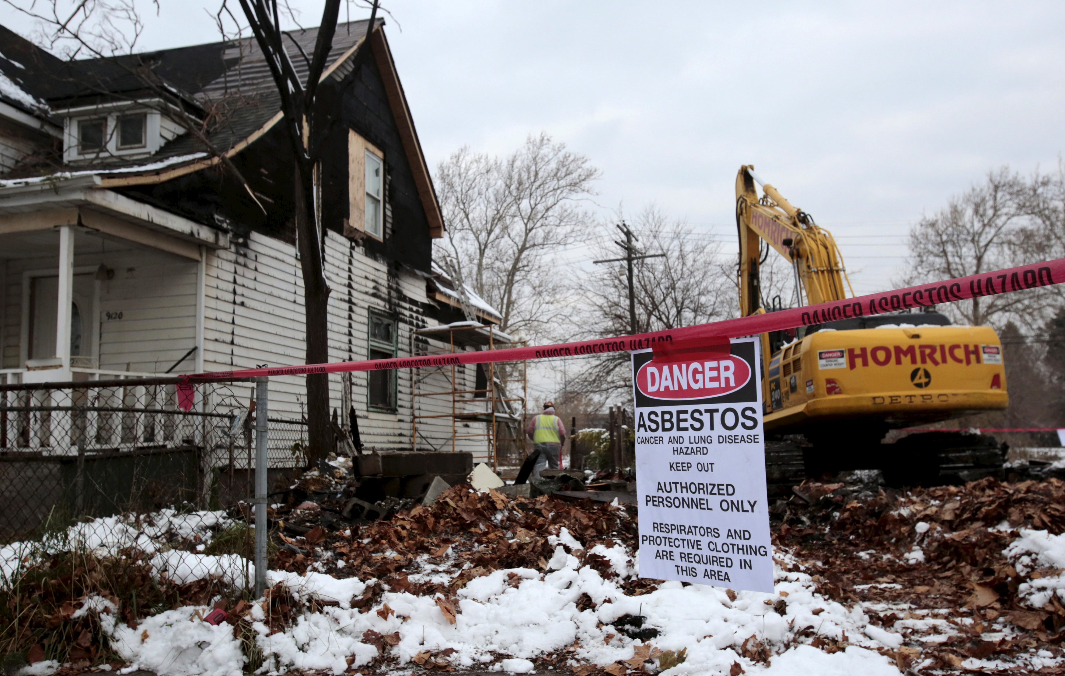 A sign is seen as a demolition crew removes the remains of a demolished home in Detroit