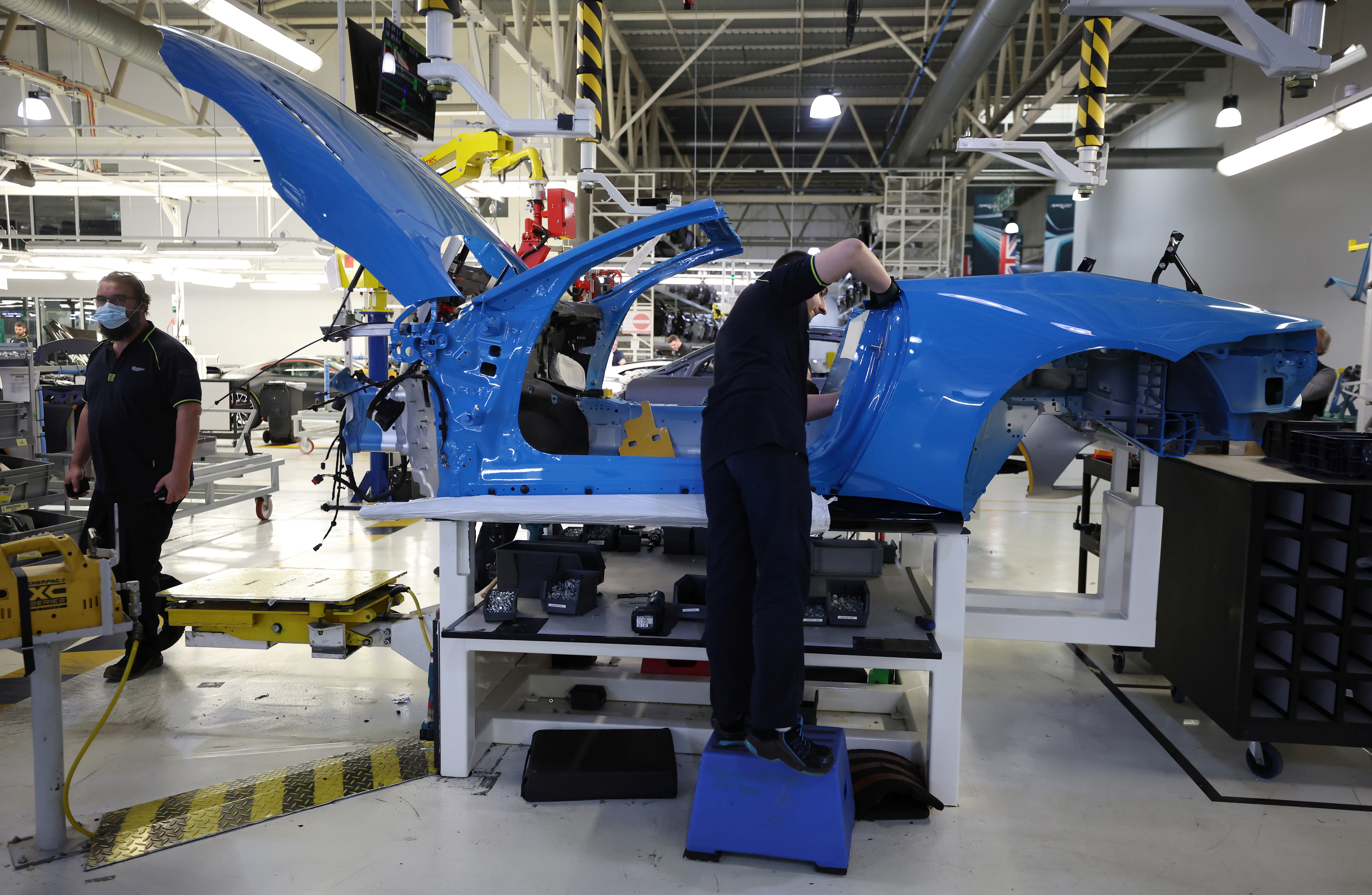 An employee works on an Aston Martin DBS at the company’s factory in Gaydon