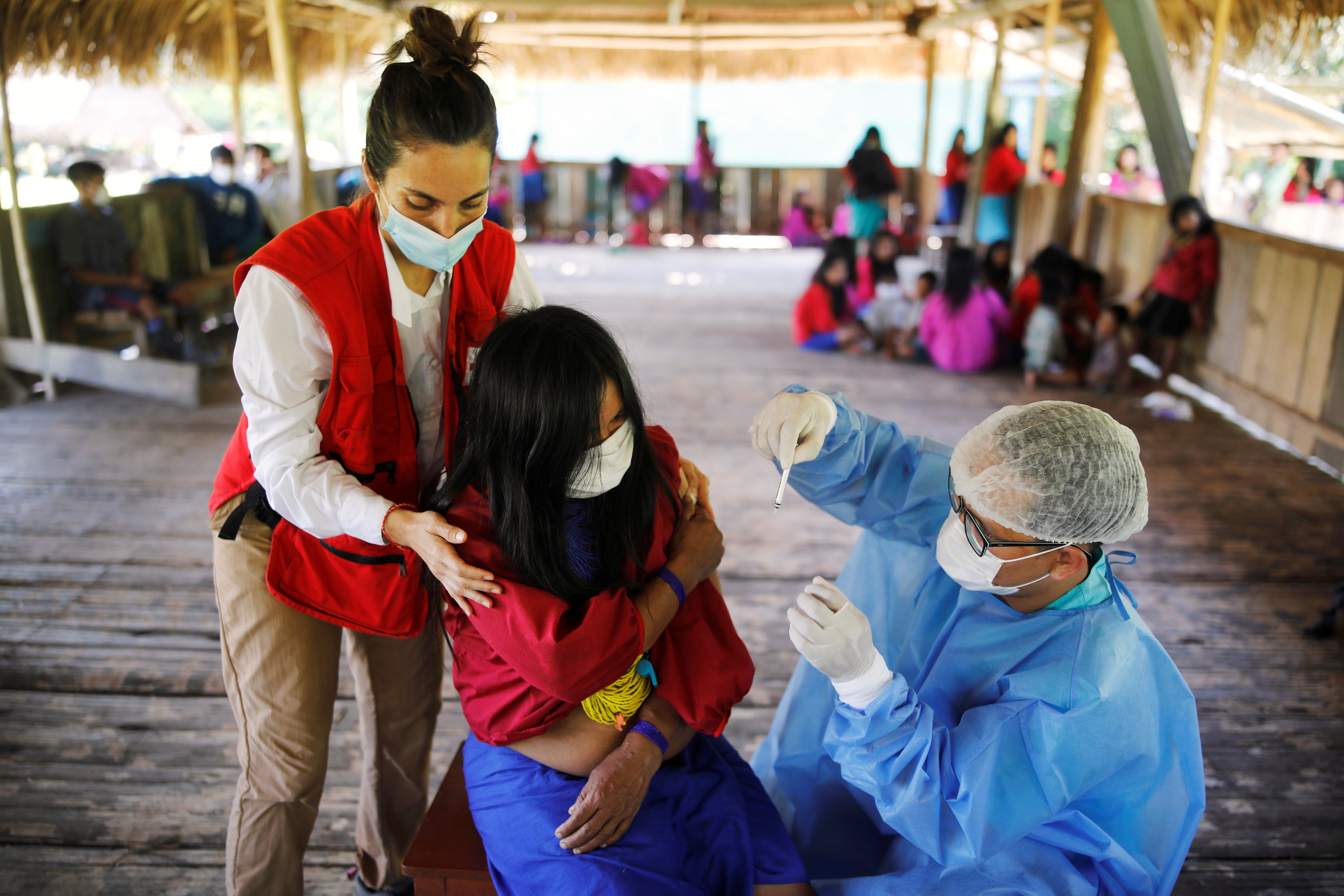 A woman is administered a vaccine for the coronavirus disease (COVID-19) during an outreach by healthcare workers who traveled by river into the Amazon rainforest to educate people from the indigenous Urarina population about the disease and offer medical care, in Mangual, Peru October 11, 2021. Picture taken October 11, 2021. REUTERS/Sebastian Castaneda