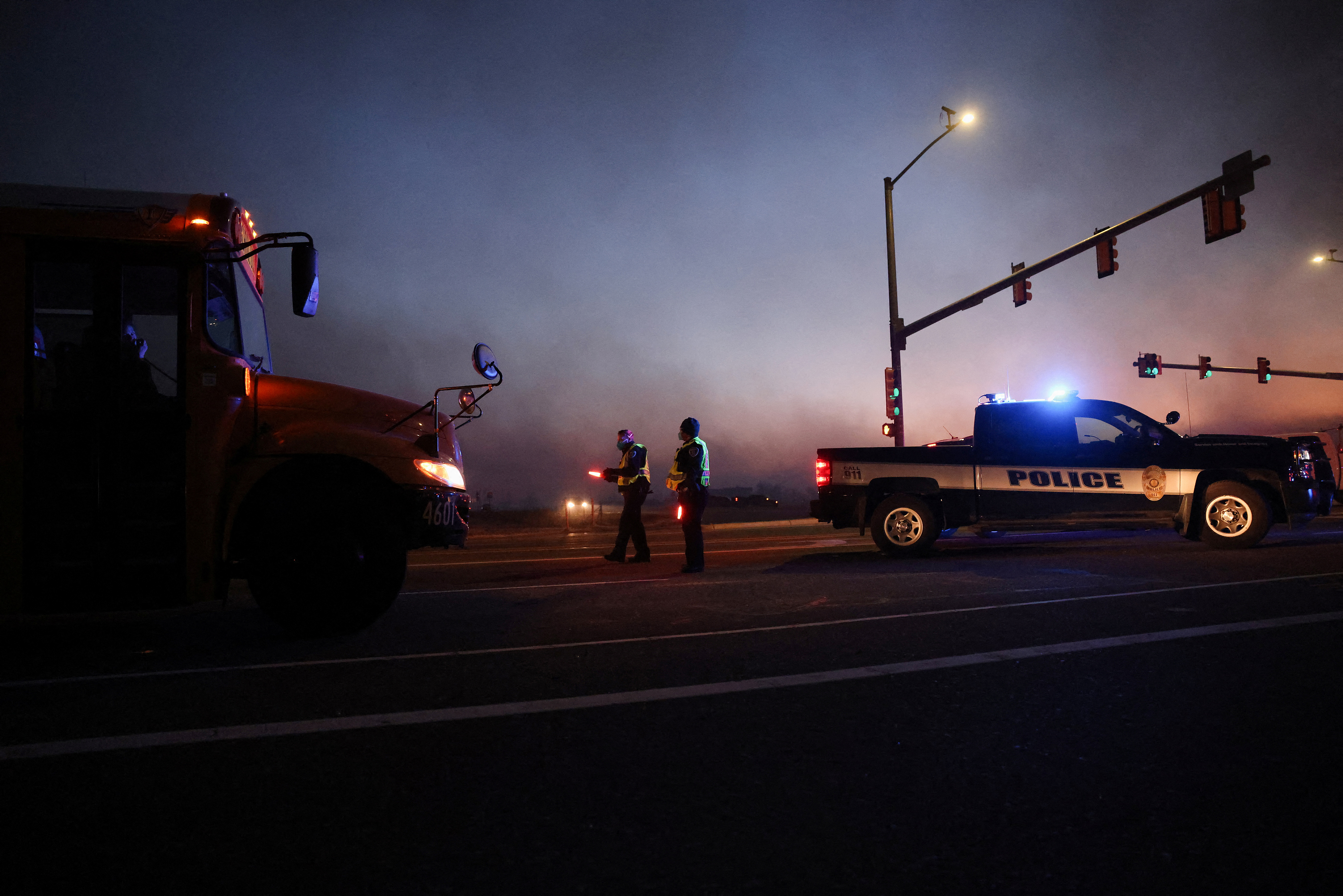 Police officers keep watch after wind-driven wildfires prompted evacuation orders, near Boulder, Colorado, U.S. December 30, 2021.  REUTERS/Kevin Mohatt