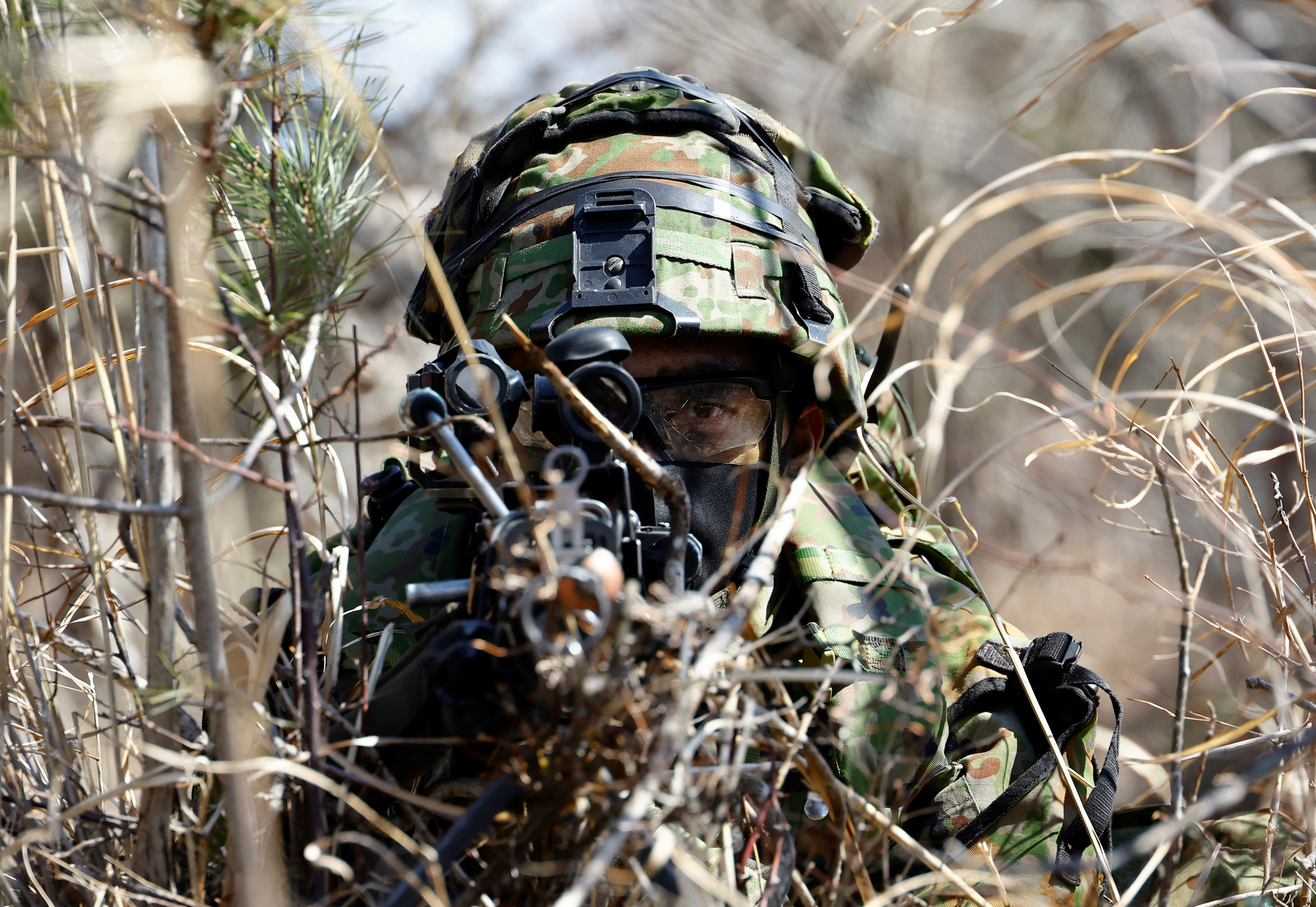 A member of the Japanese Self-Defense Force’s Amphibious Rapid Deployment Brigade aims his gun as he takes a position during joint airborne landing exercises with the U.S.Marine Corps in Gotemba