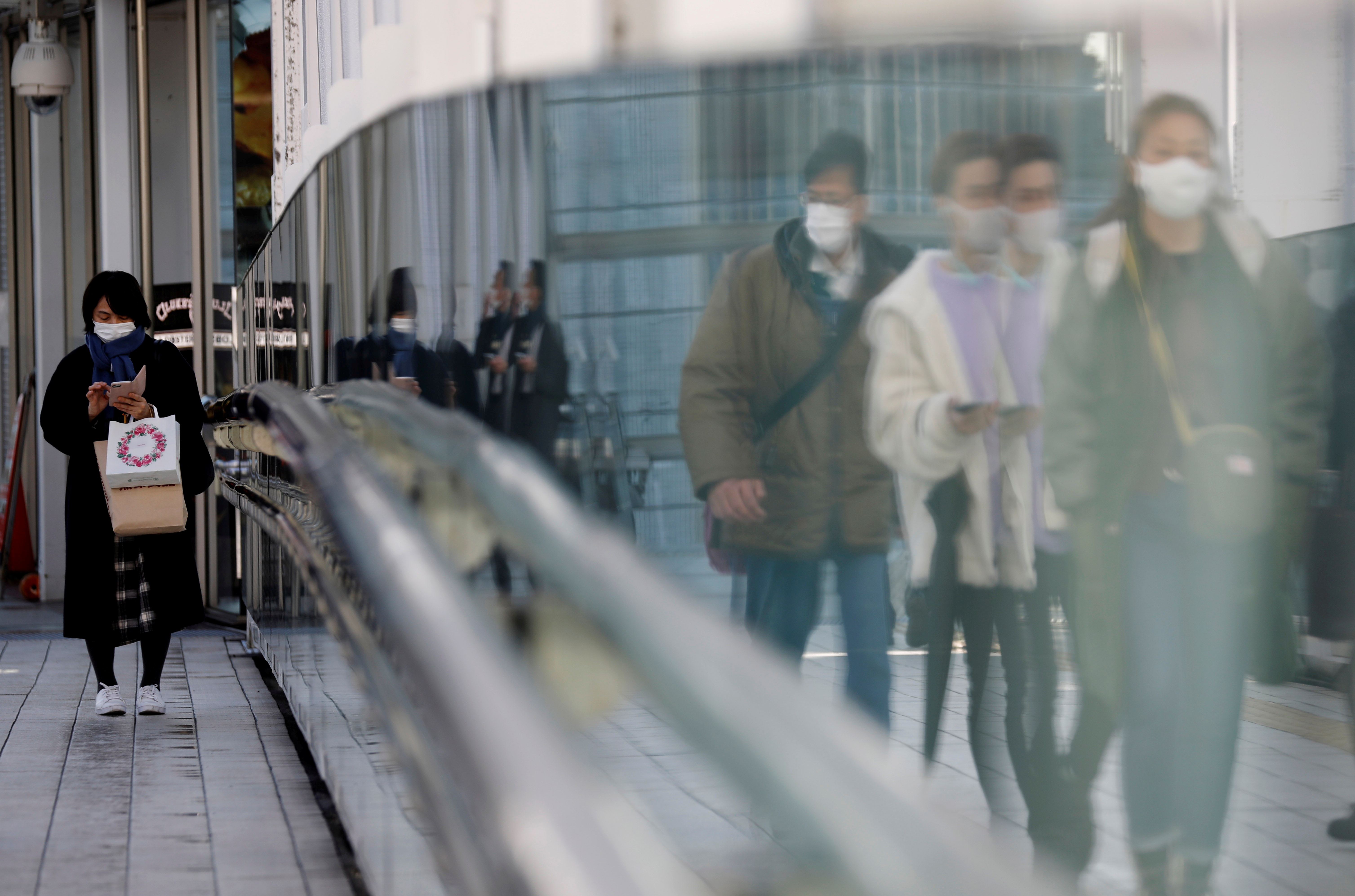 Pedestrians wearing protective masks amid the coronavirus disease (COVID-19) outbreak, make their way in Tokyo, Japan, February 2, 2021. REUTERS/Kim Kyung-Hoon/File Photo