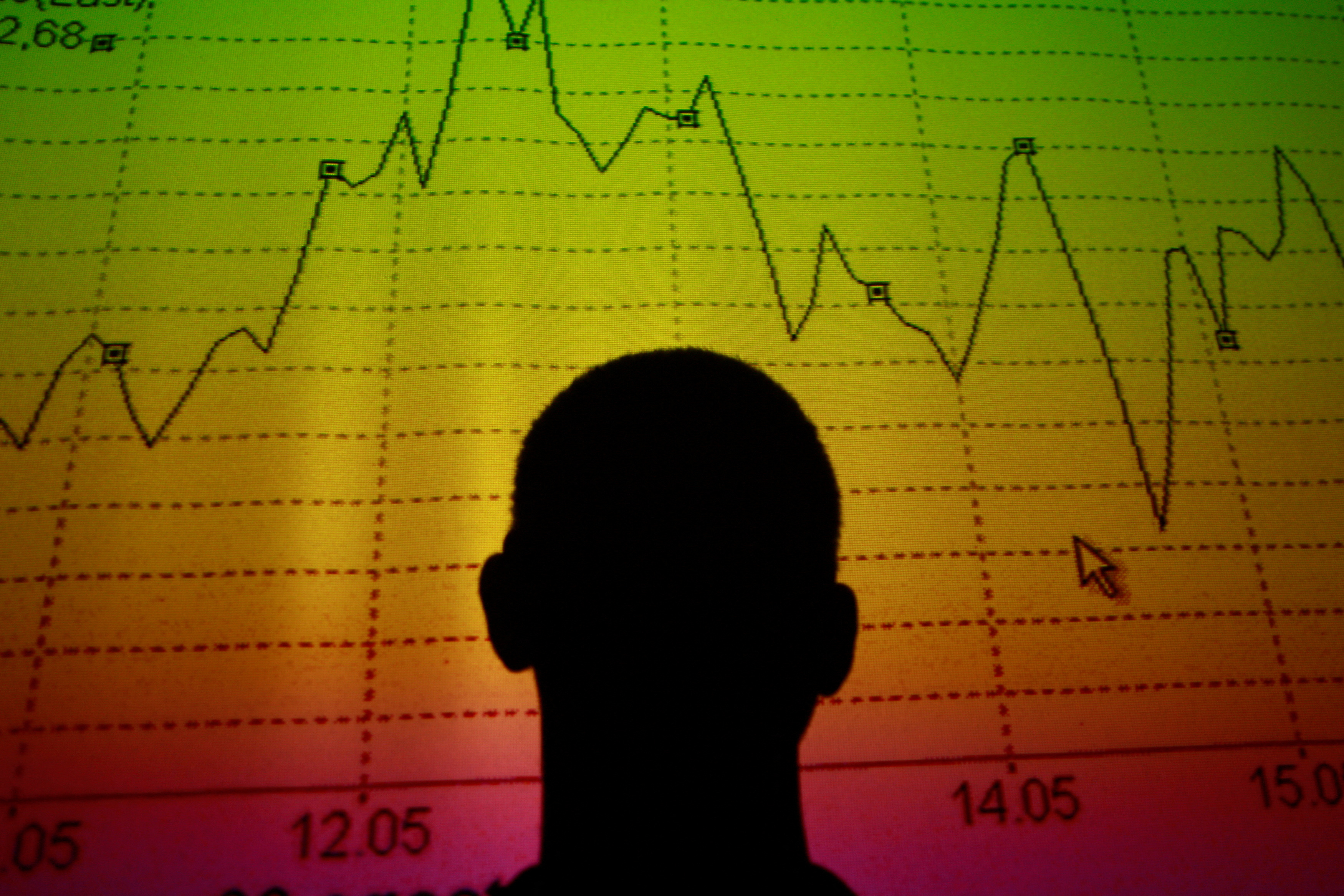 Photo illustration of man silhouetted in an electronic board showing the Italian equity market index in Rome