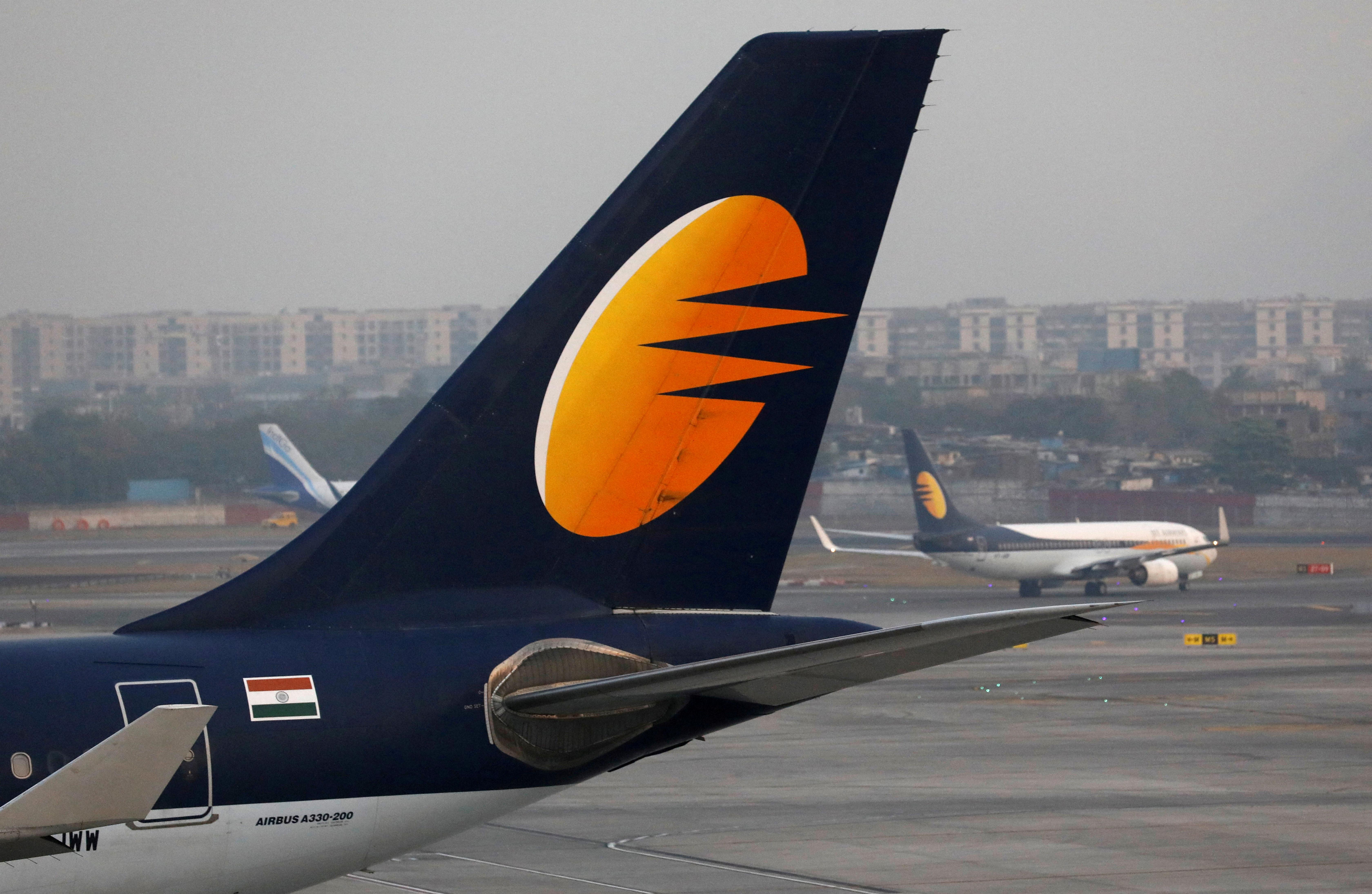 A Jet Airways plane is parked as other moves to runway at the Chhatrapati Shivaji International airport in Mumbai