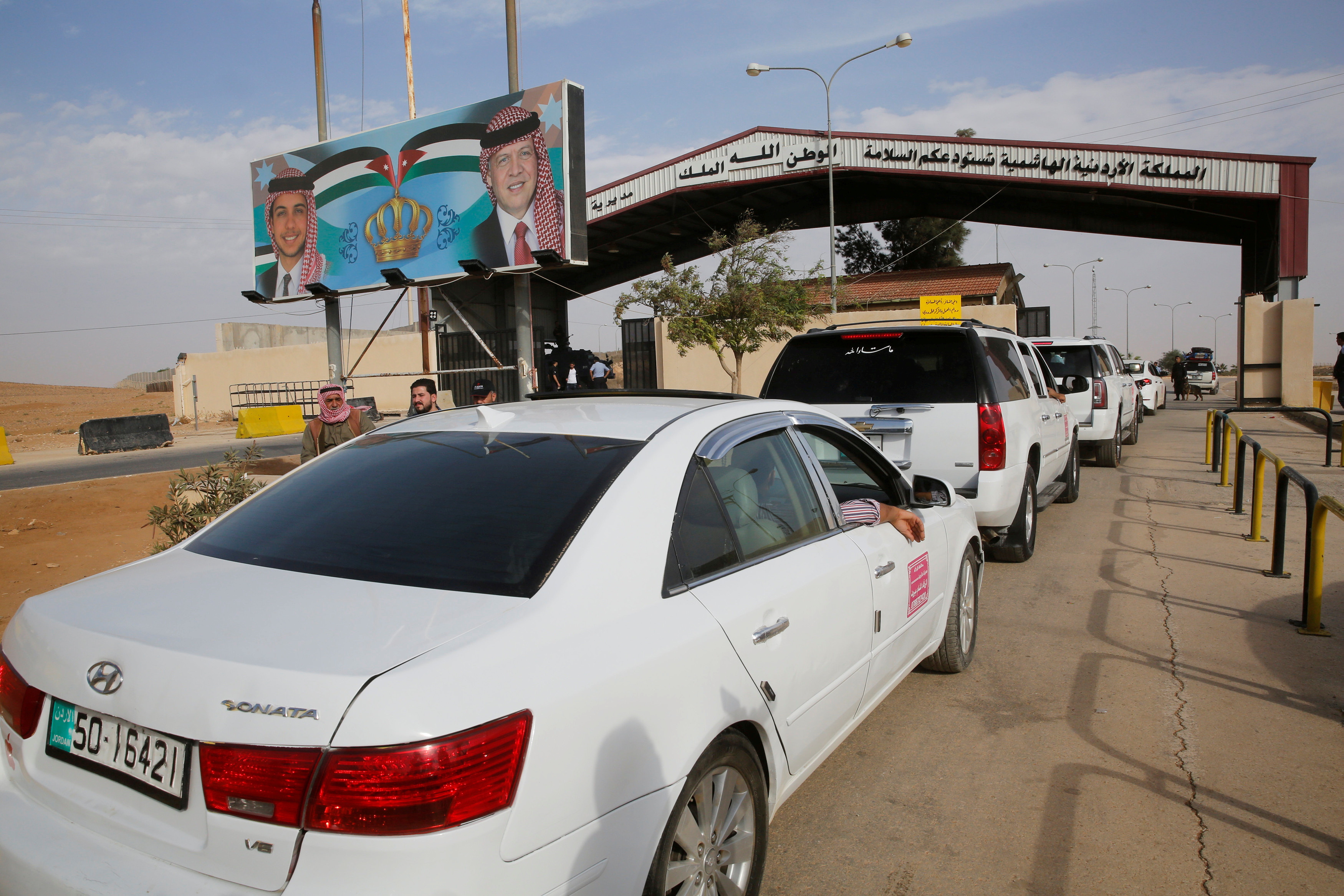 Jordanian police officers check the cars at Jordan's Jaber border crossing, near Syria's Nassib checkpoint, near Mafraq