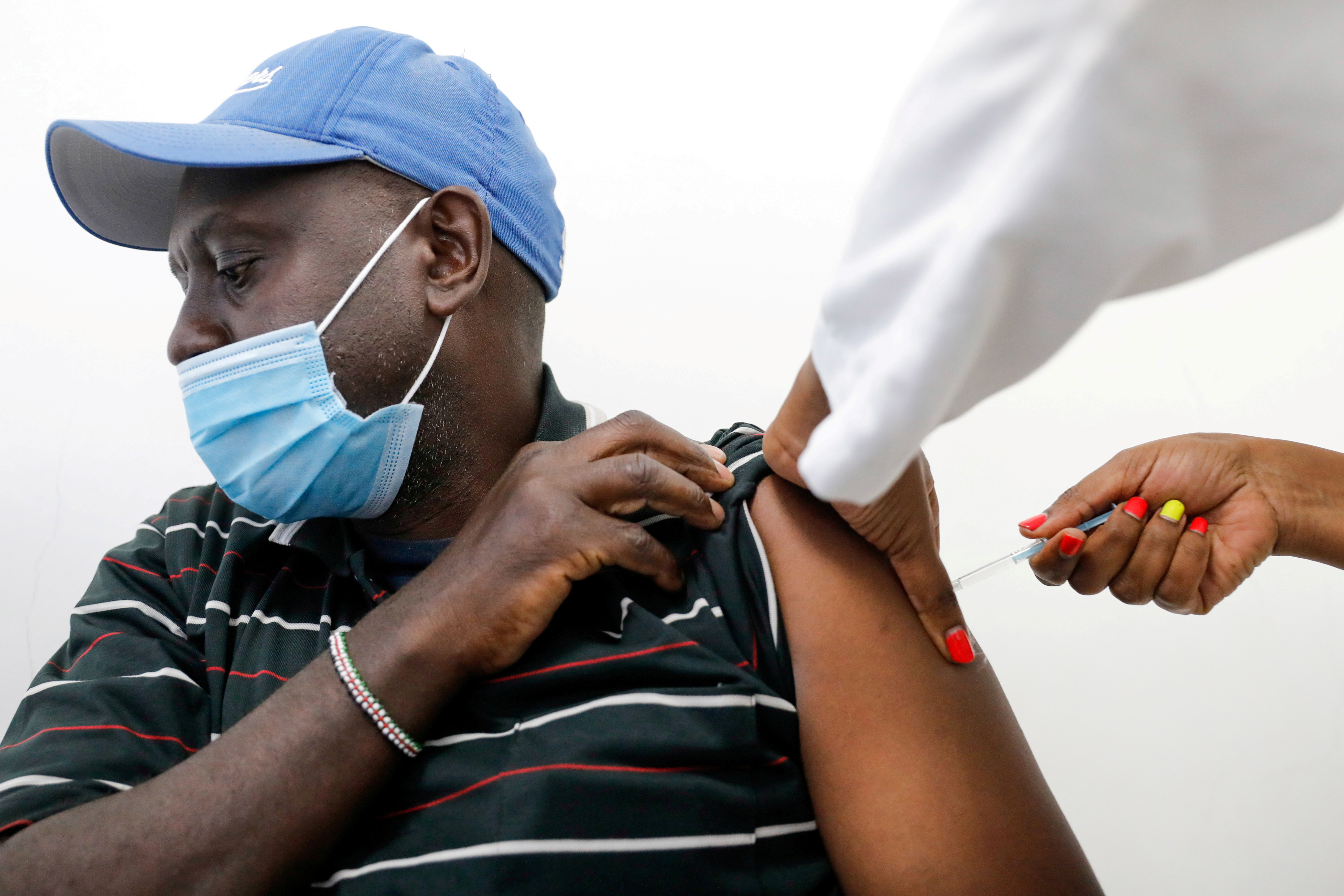 A medical worker gives a dose of AstraZeneca's coronavirus disease (COVID-19) vaccine to a man, at the Ruaraka Uhai Neema Hospital in Nairobi, Kenya, April 8, 2021. REUTERS/Baz Ratner
