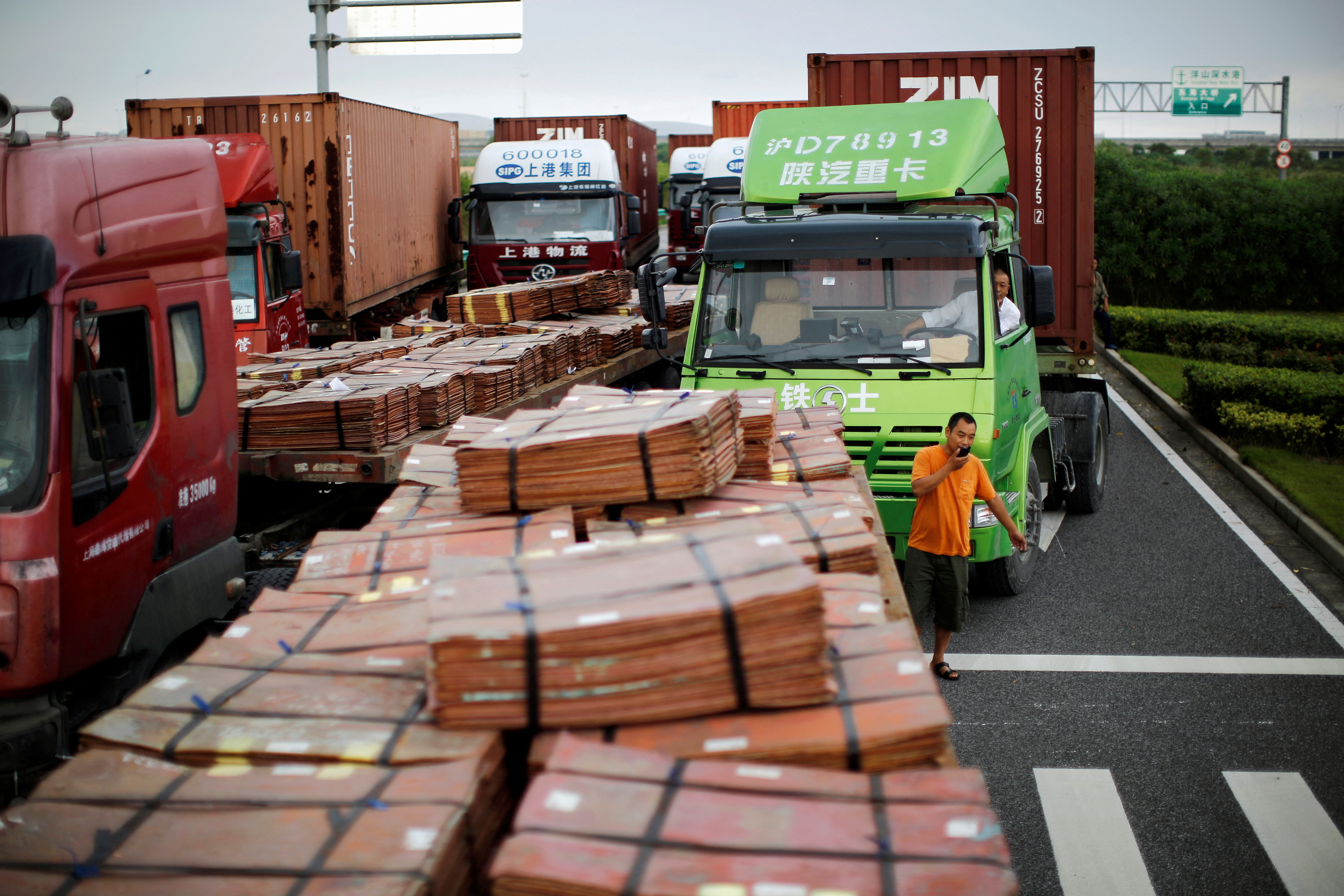Trucks carrying copper and other goods are seen waiting to enter an area of the Shanghai Free Trade Zone, in Shanghai