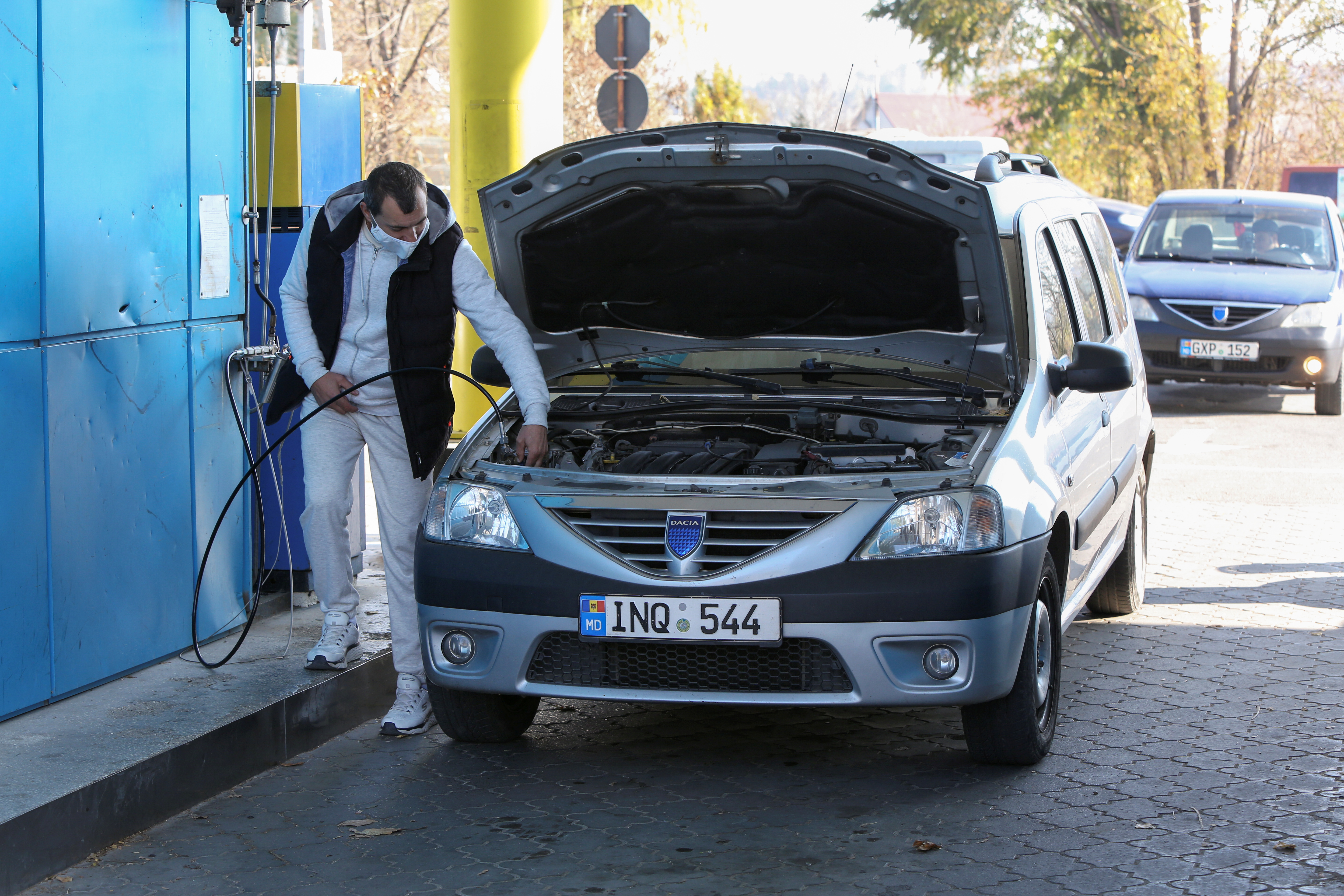 A man fills a car with natural gas at a fuel station in Chisinau