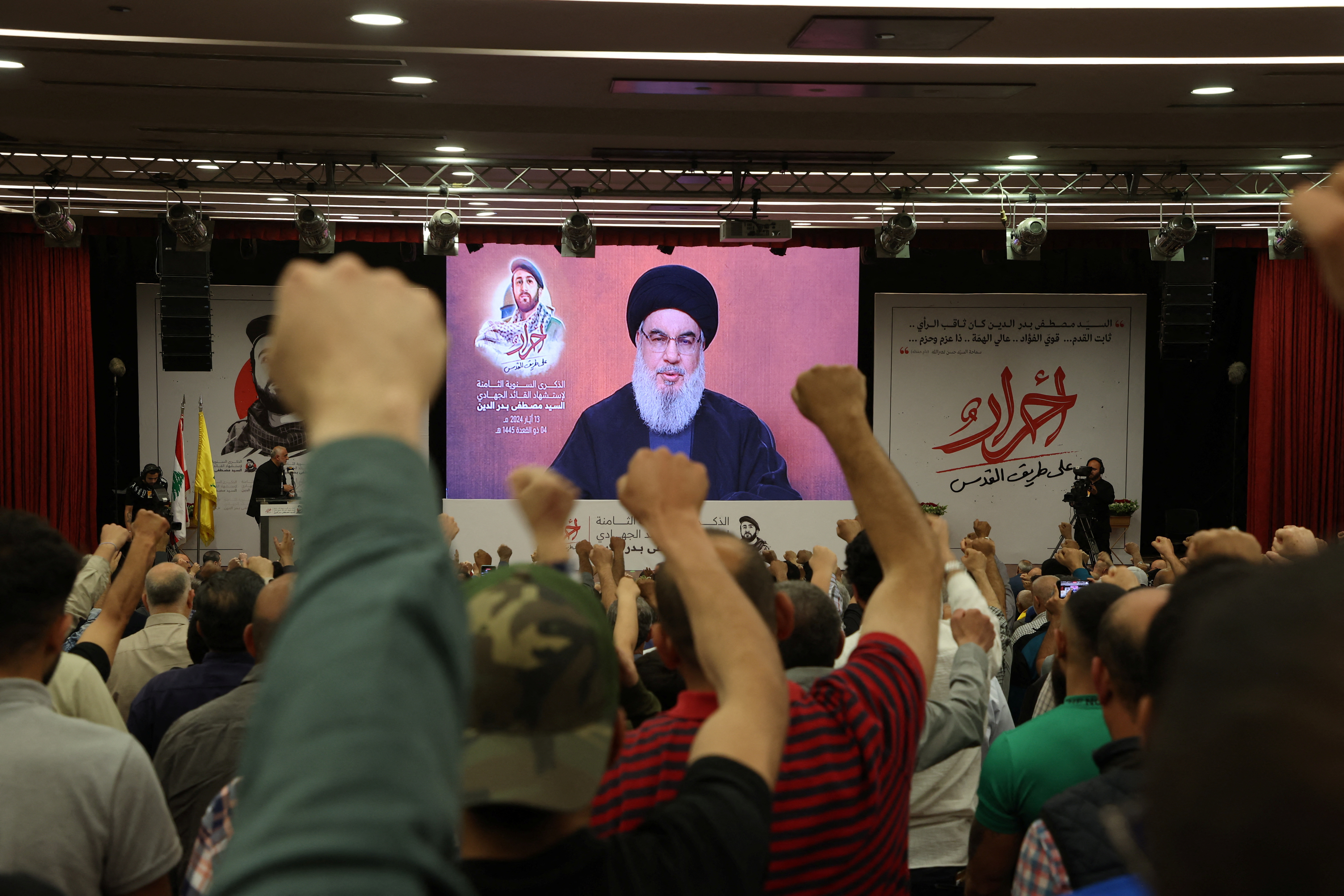Supporters of Lebanon's Hezbollah leader Sayyed Hassan Nasrallah gesture as Narallah gives a televised address during a rally in Beirut's southern suburbs