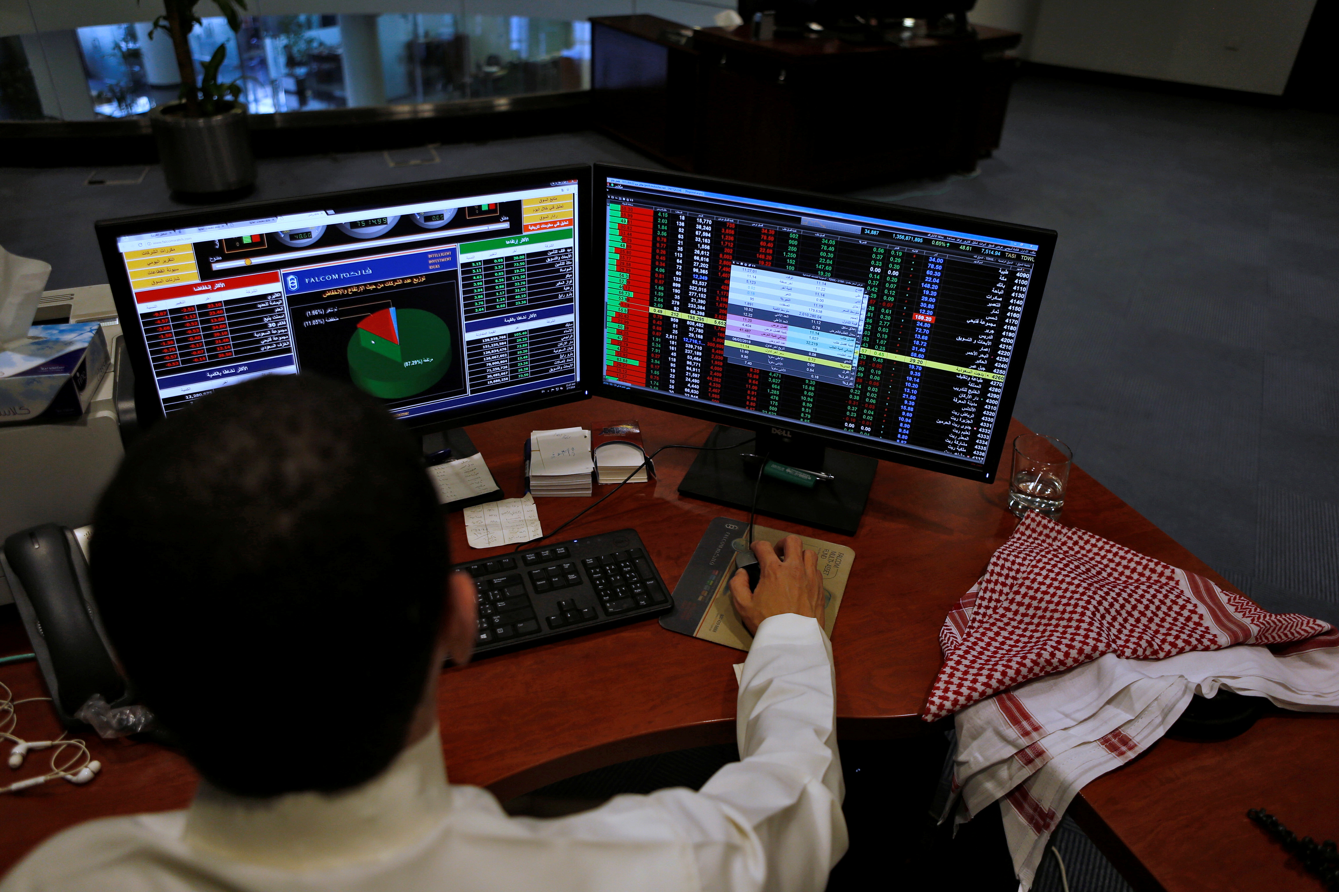 A Saudi trader observes the stock market on monitors at Falcom stock exchange agency in Riyadh