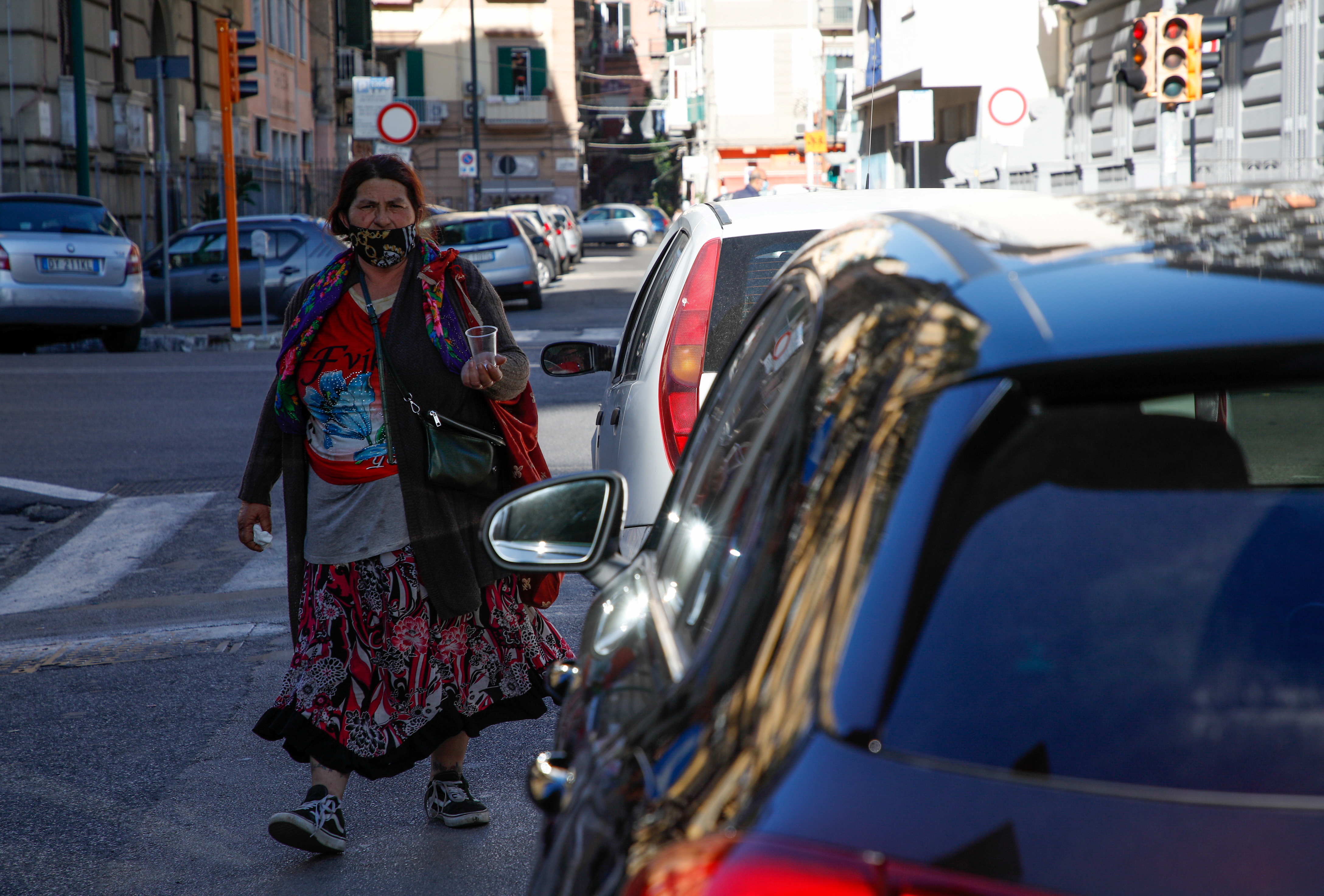 A woman begs on the street in Naples