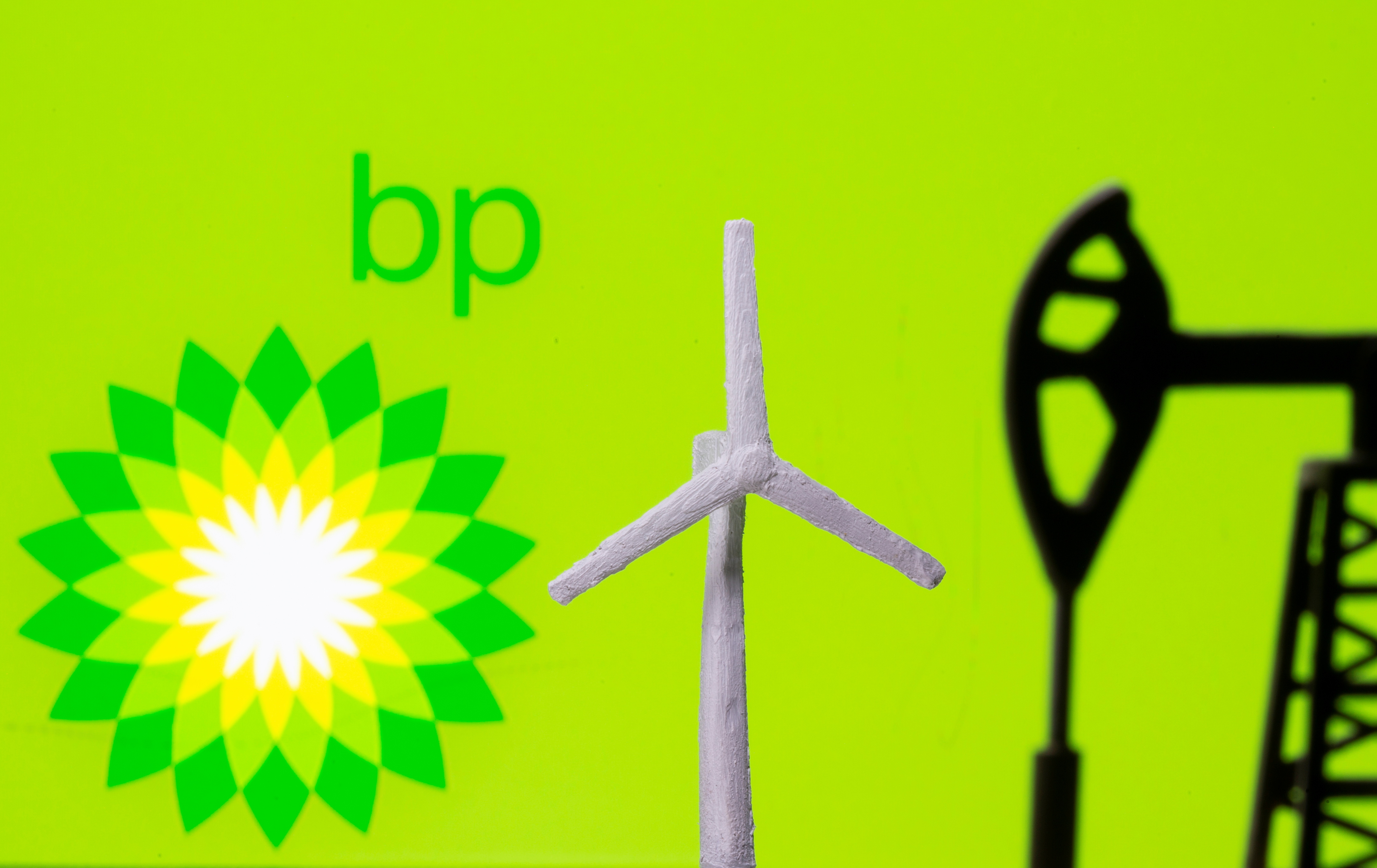 A 3D printed windmill and oil pump jack are seen in front of displayed BP (British Petroleum) logo in this illustration picture