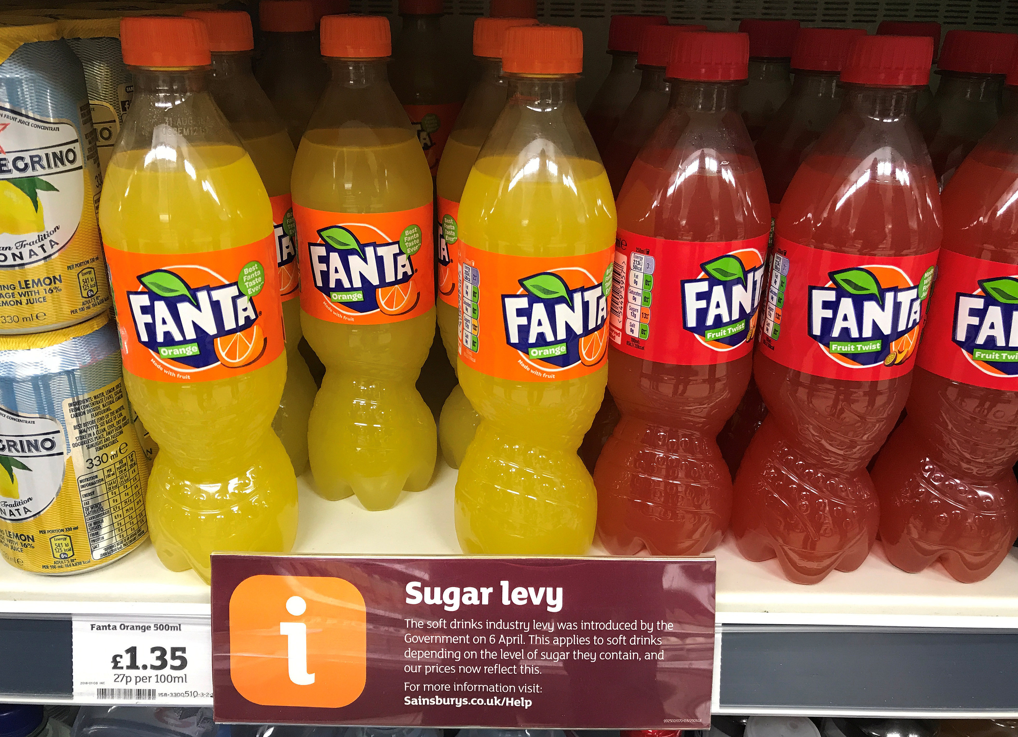 A sign informing shoppers about the UK sugar Levy is seen on a shelf of Fanta soft drinks inside a Sainsbury's supermarket in Manchester.