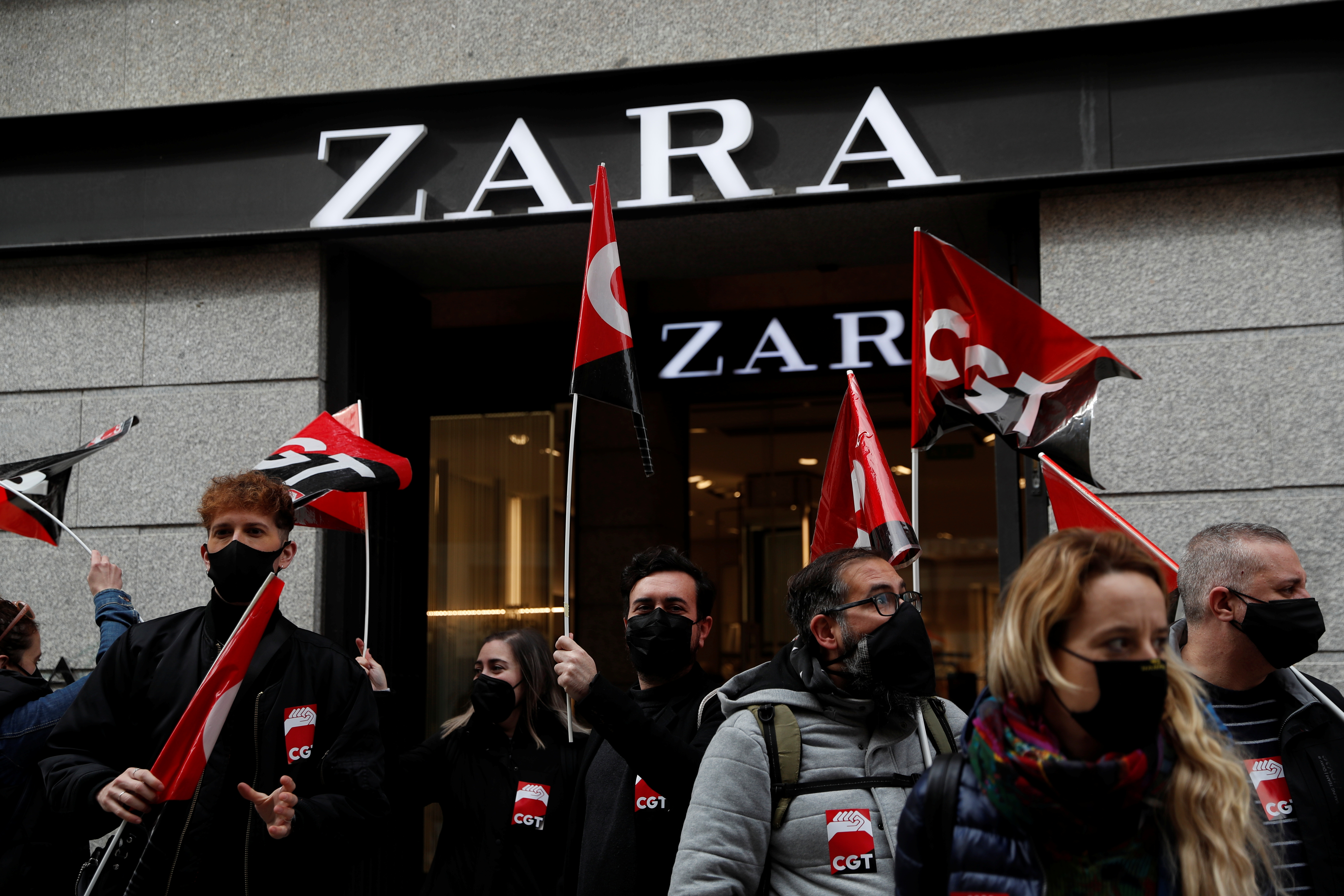 People hold flags from Spain's CGT labour union as they protest outside a Zara clothing store, an Inditex brand, in Madrid, Spain, February 25, 2021. REUTERS/Susana Vera