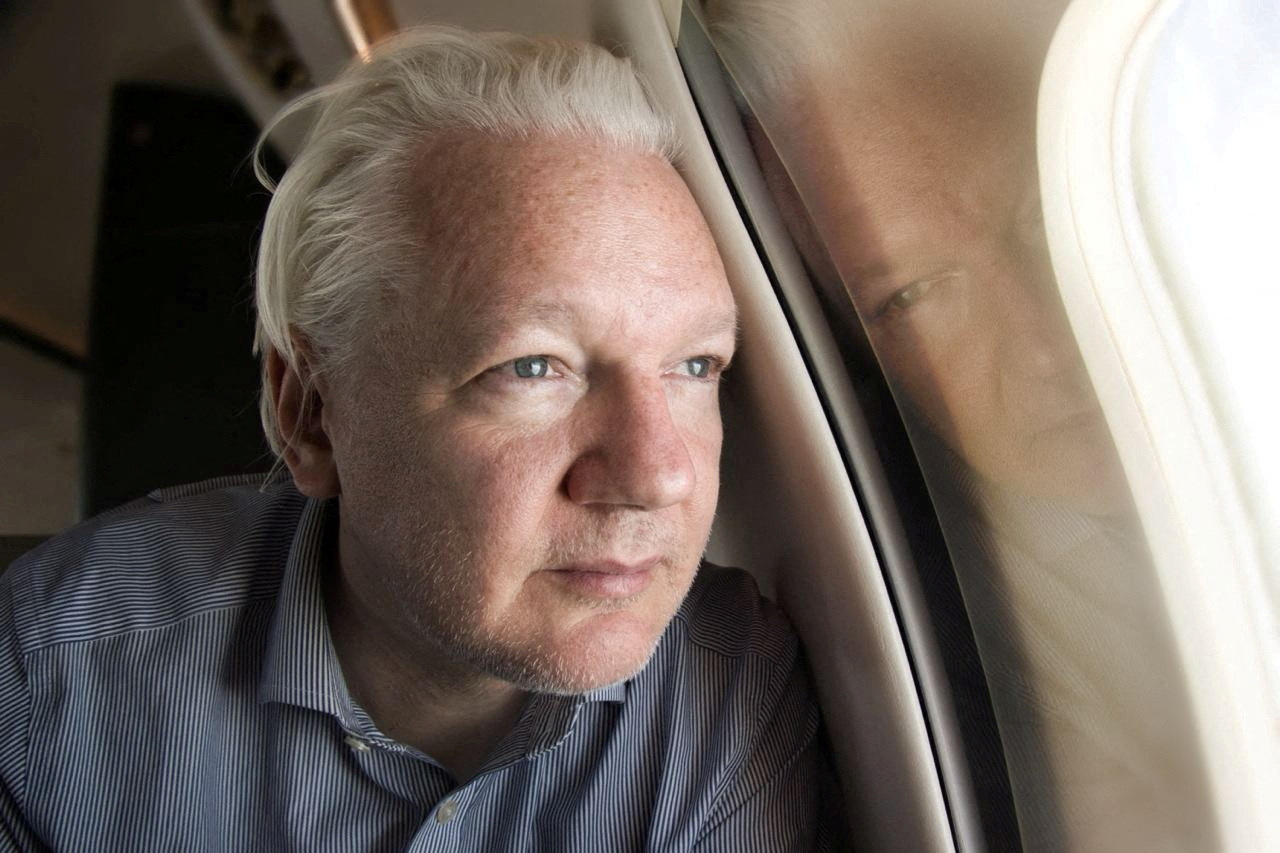 WikiLeaks founder Julian Assange looks out a plane's window