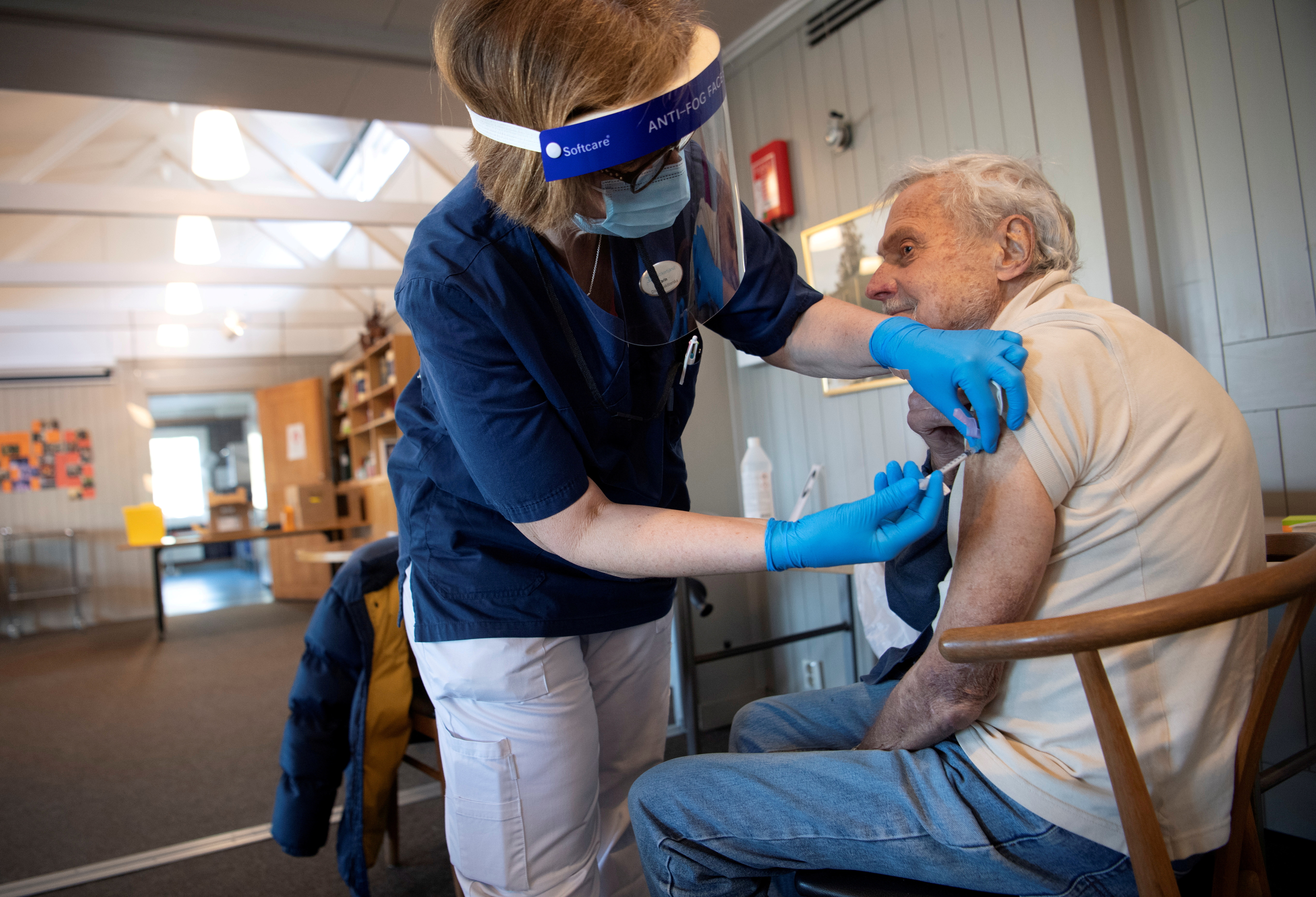 A health worker vaccinates an elderly person with Pfizer's COVID-19 vaccine at a temporary vaccination clinic in a church in Sollentuna, north of Stockholm, Sweden March 2, 2021. Fredrik Sandberg/TT News Agency/via REUTERS  