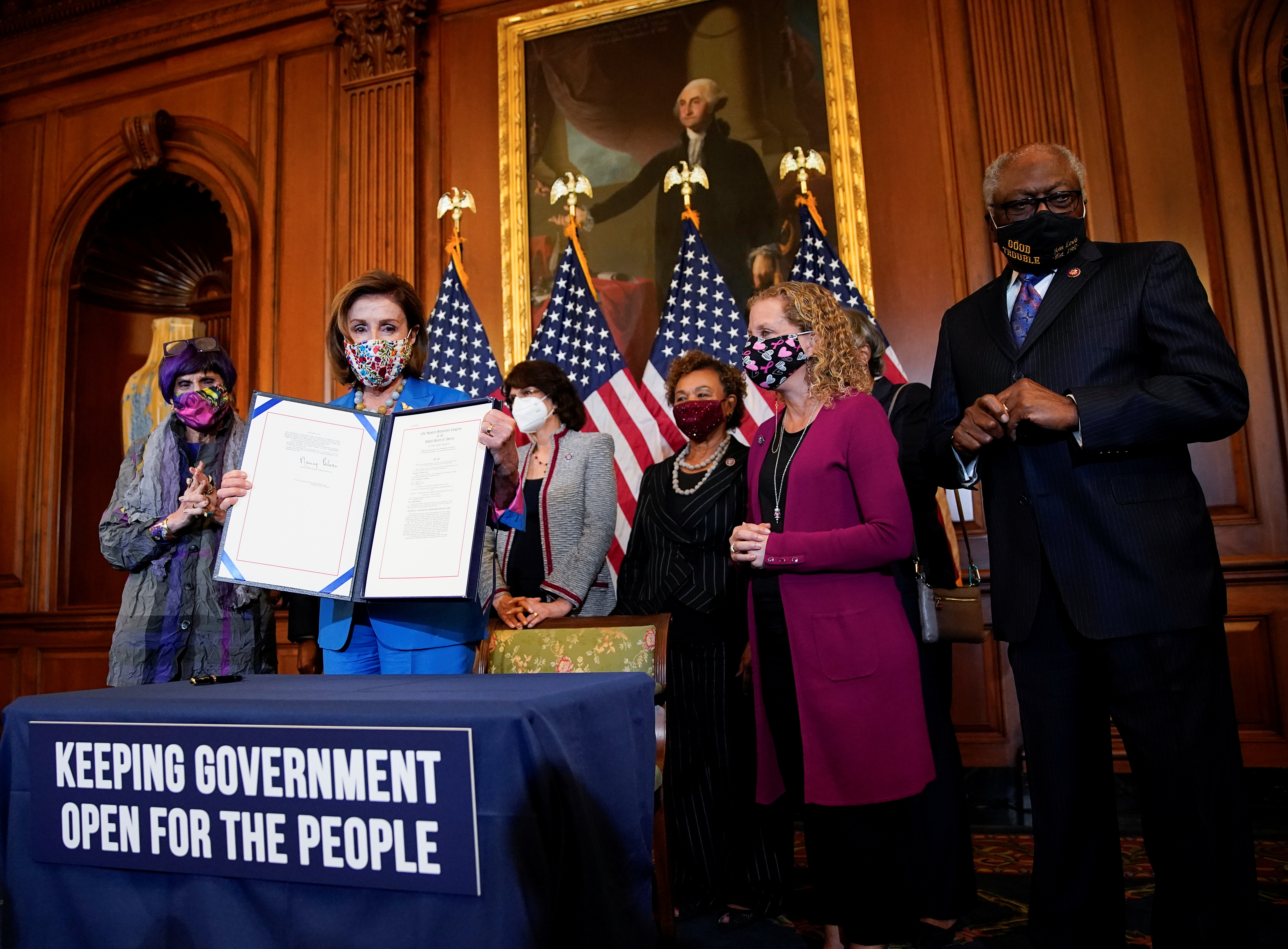 U.S. House Speaker Nancy Pelosi (D-CA) is flanked by members of the House Democratic Caucus as she holds the continuing resolution she signed to avoid a U.S. government shutdown during a bill enrollment ceremony on Capitol Hill in Washington, U.S., September 30, 2021. REUTERS/Elizabeth Frantz    