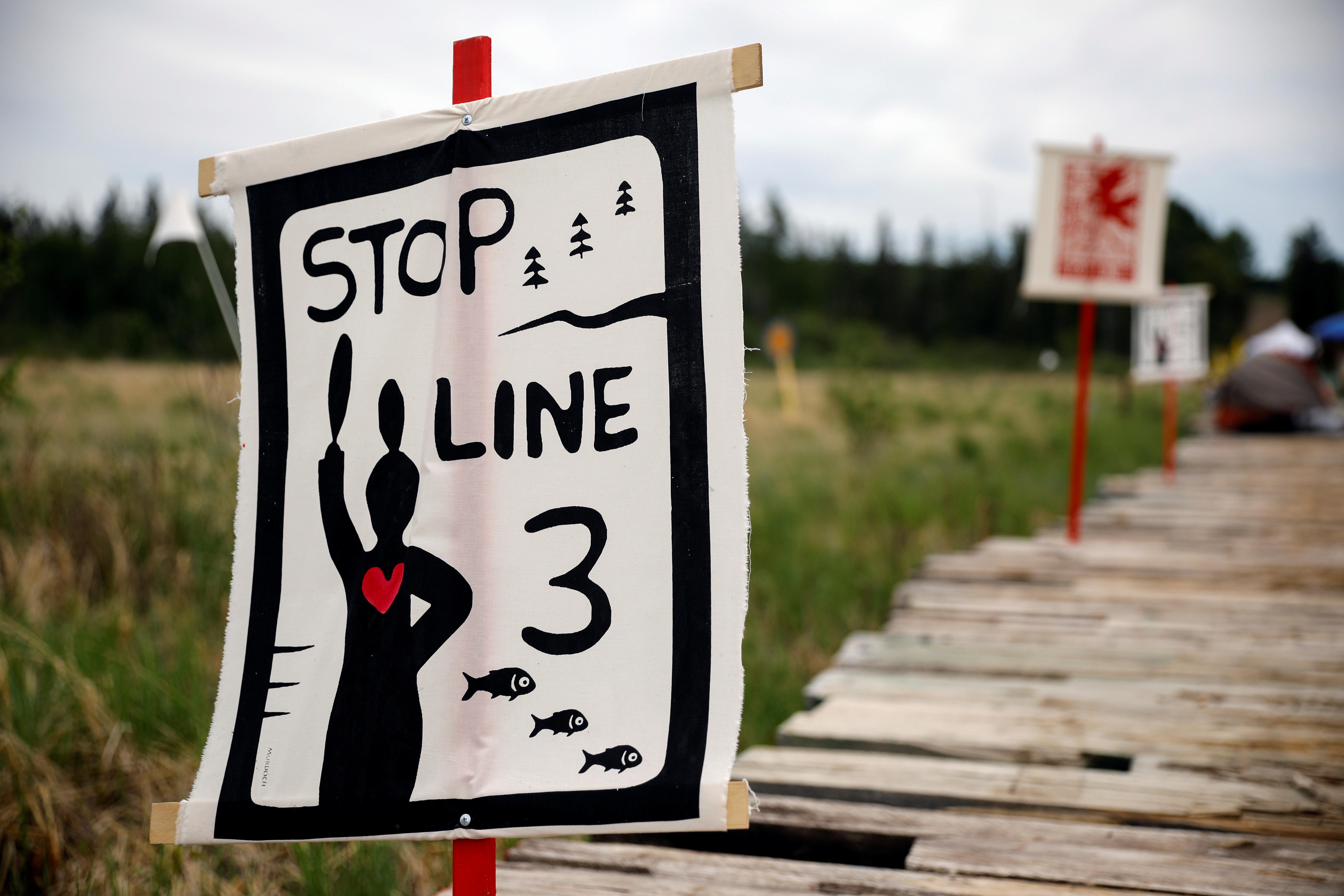 Protest signage on display at a camp established by indigenous leaders and water protectors at the Mississippi headwaters, one body of water the Line 3 pipeline will cross following a series of demonstrations in protest of the Line 3 pipeline, built by Enbridge Energy, in Solway, Minnesota, U.S., June 8, 2021. Picture taken June 8, 2021.  REUTERS/Nicholas Pfosi