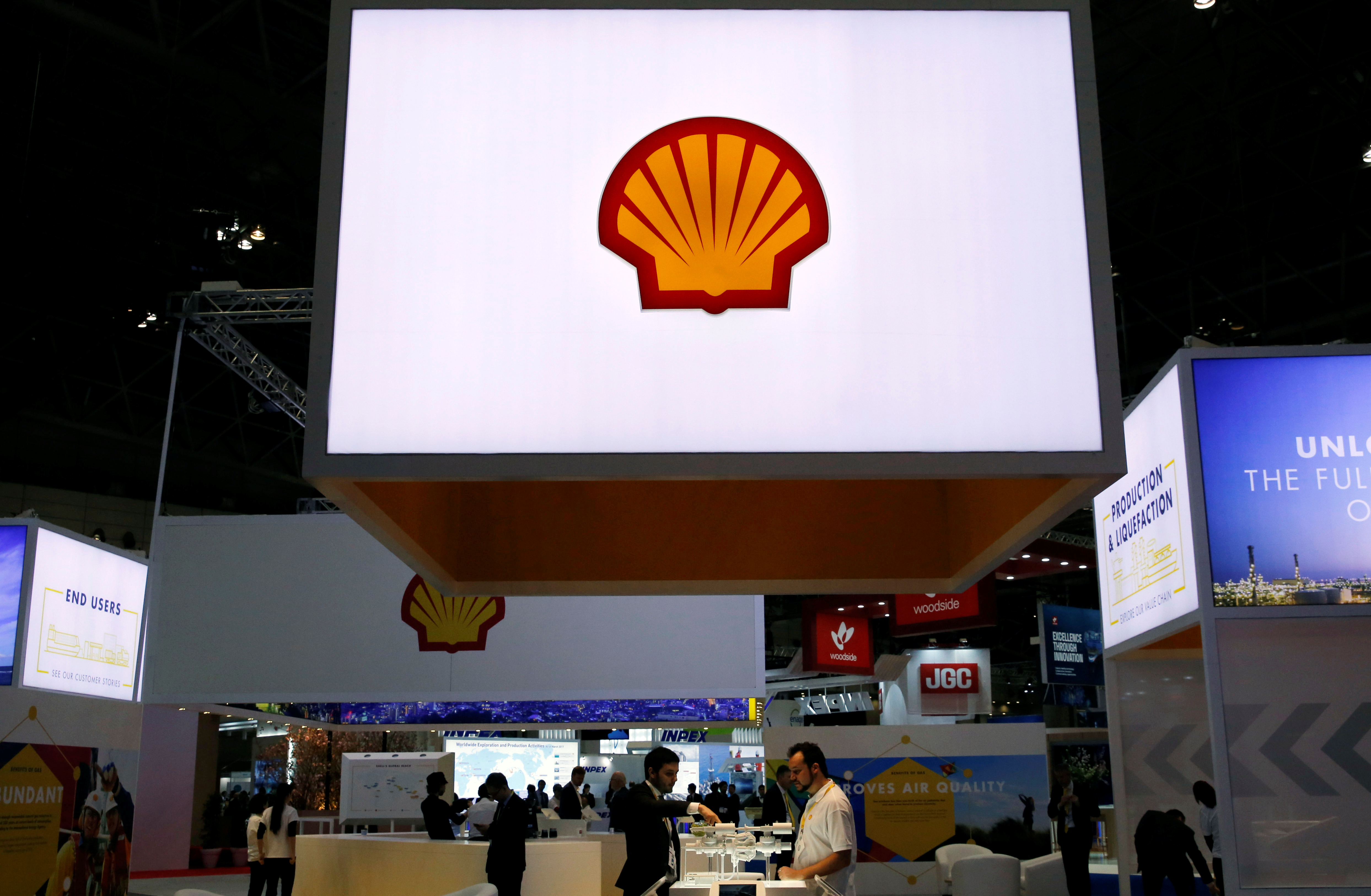 Staff members work at the booth of Royal Dutch Shell at Gastech, the world's biggest expo for the gas industry, in Chiba