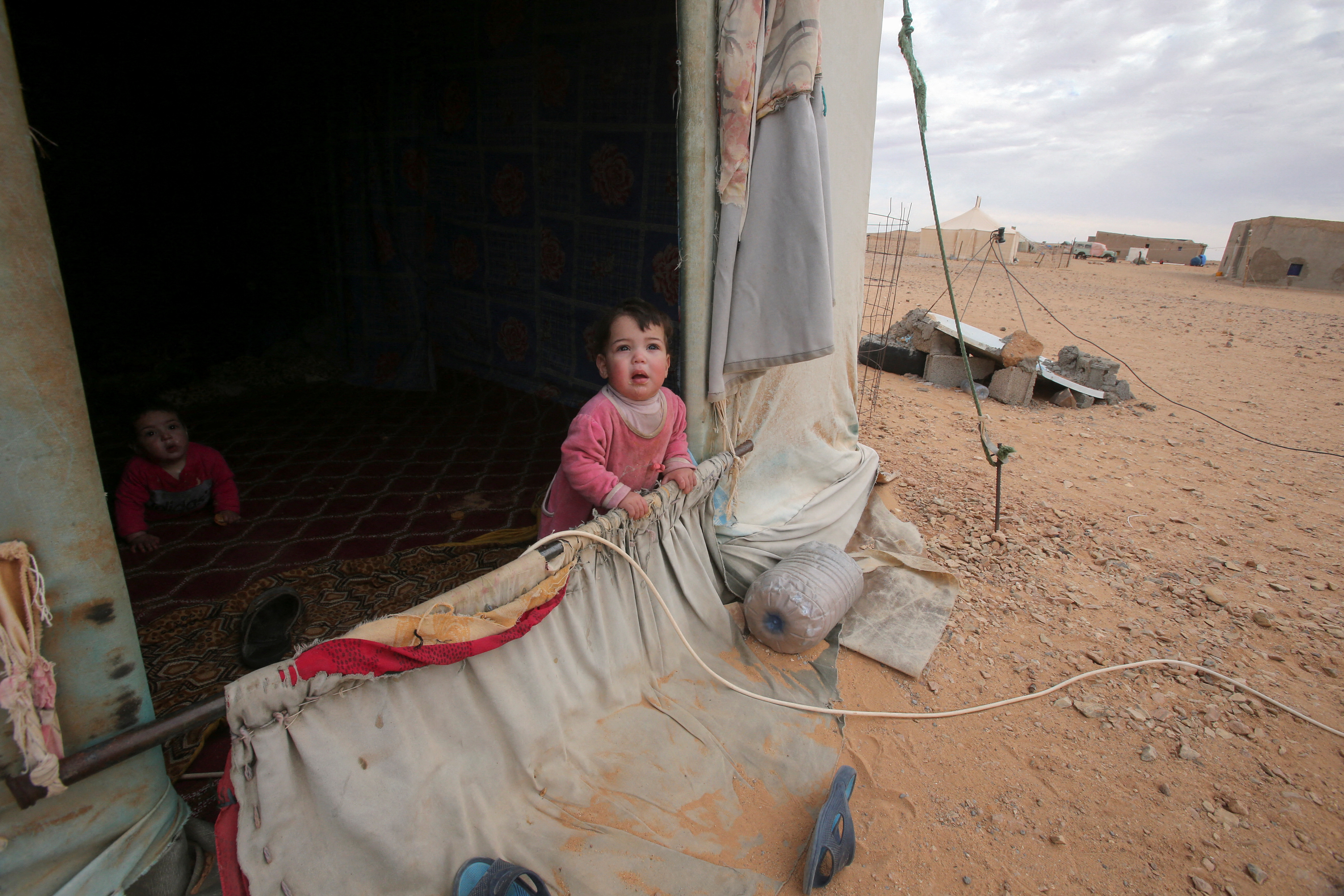A child looks out from a tent at a Sahrawi refugee camp in Tindouf