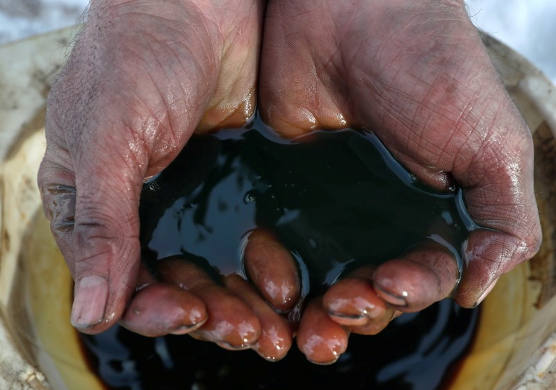 An employee demonstrates a sample of crude oil in the Irkutsk Oil Company-owned Yarakta Oil Field in Irkutsk Region