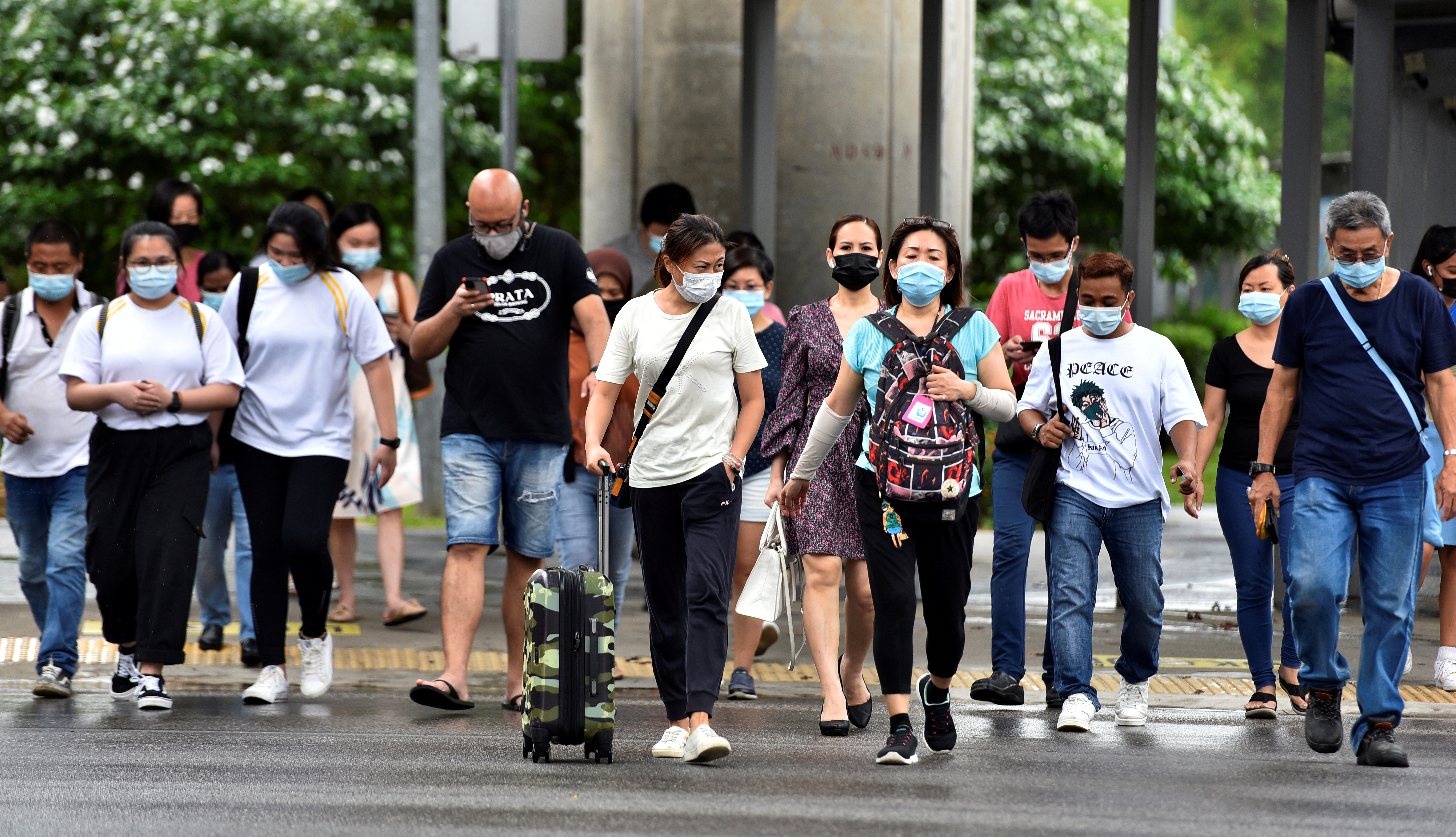 People wearing face masks cross a road amid the coronavirus disease (COVID-19) outbreak in Singapore