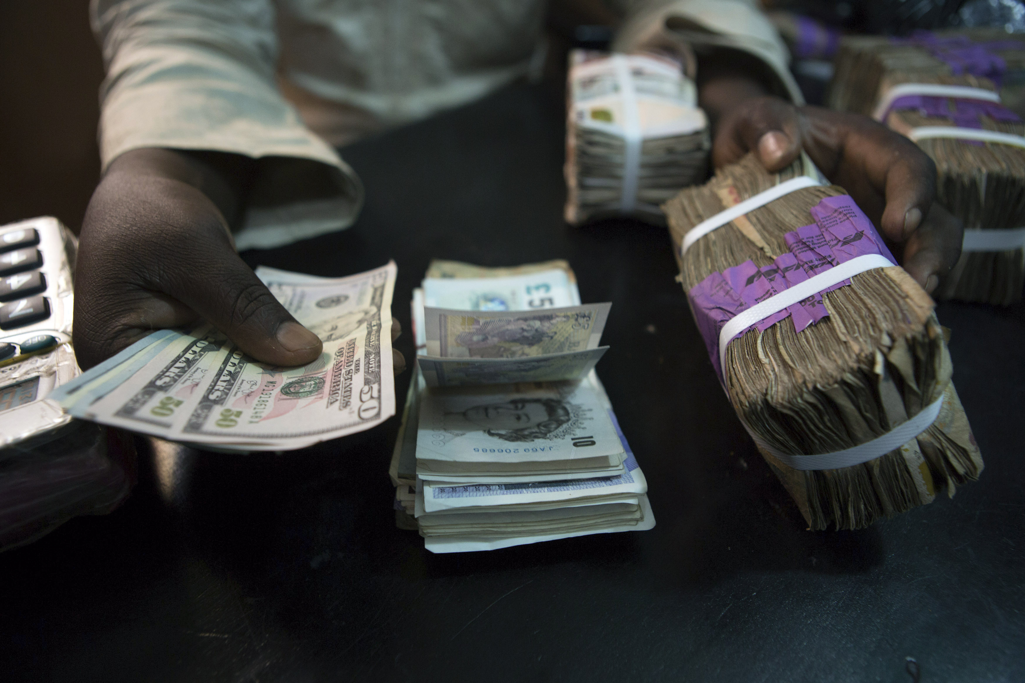 A trader changes dollars with naira at a currency exchange store in Lagos