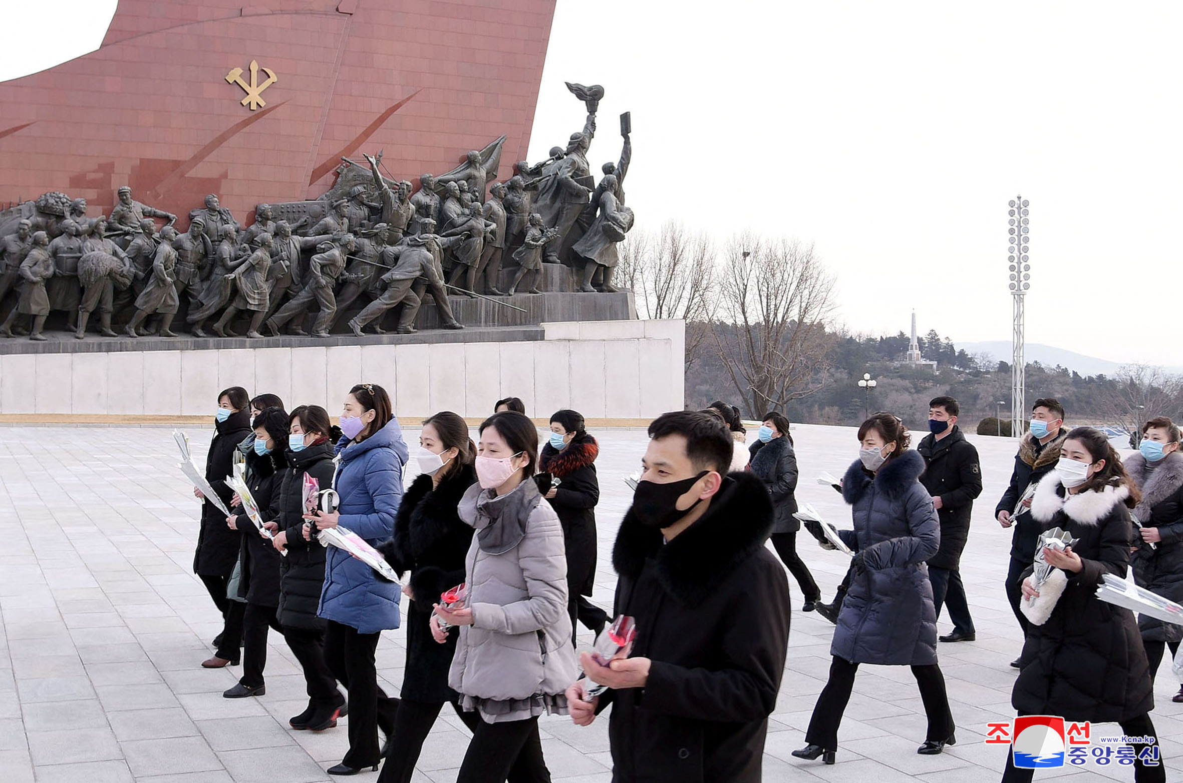 People walk to lay floral tributes to commemorate the Day of the Shining Star, the birth anniversary of late North Korean leader Kim Jong Il, at the Mansudae Grand Monument in Pyongyang