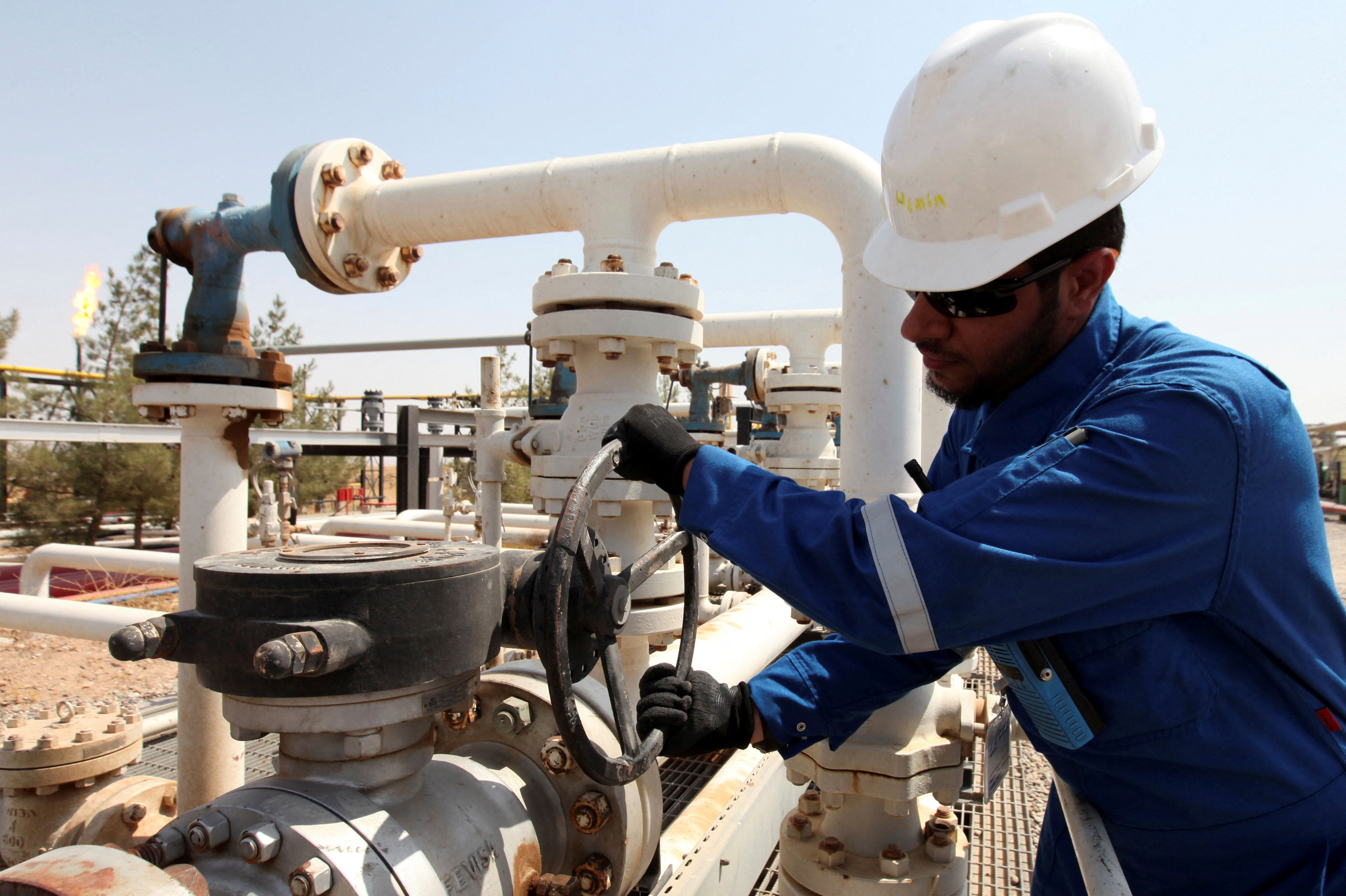 A worker adjusts a valve of an oil pipe at Taq Taq oilfield in Erbil, in Iraq's Kurdistan region