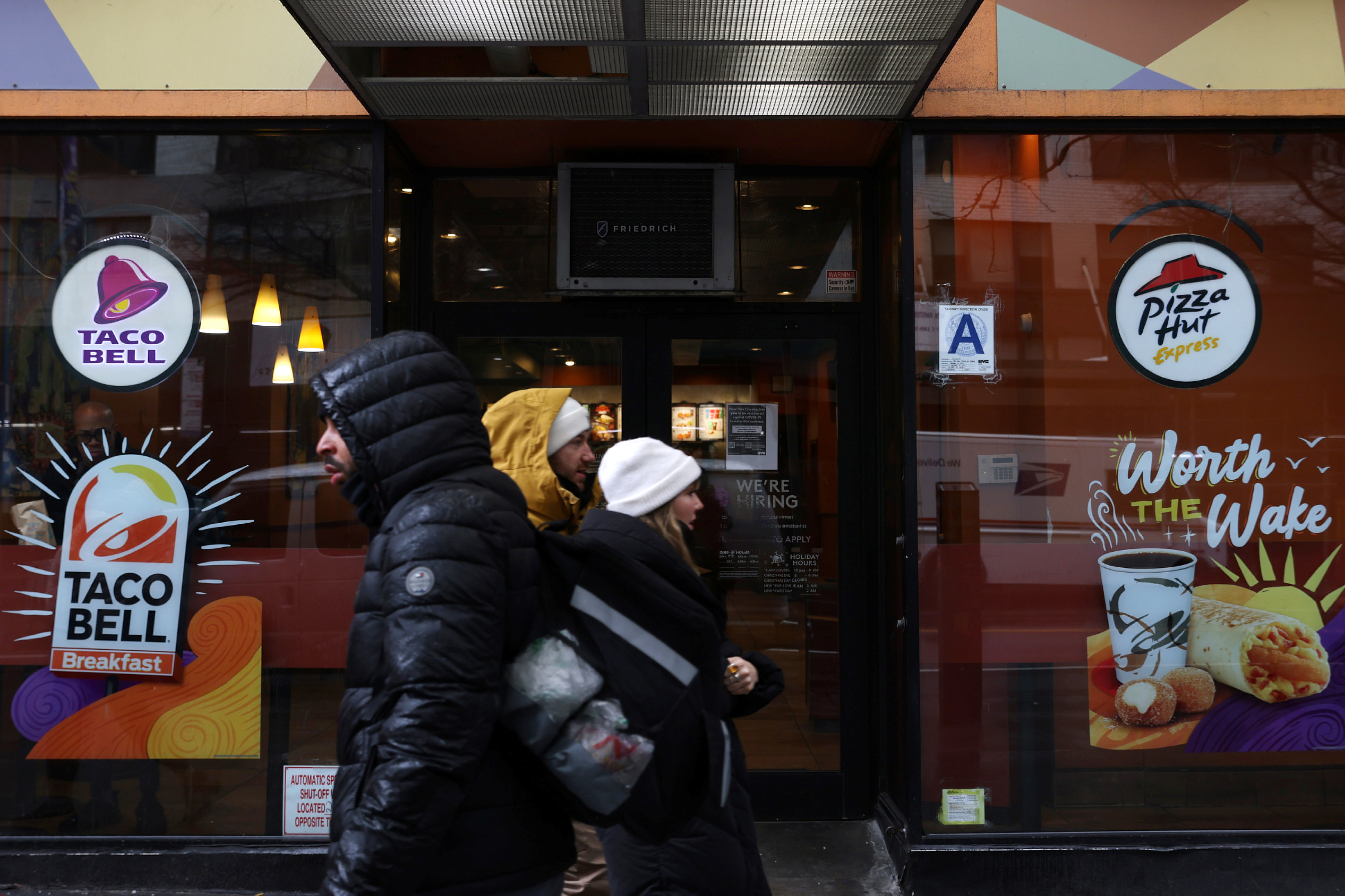 People walk by a Taco Bell and Pizza Hut, subsidiaries of Yum! Brands, Inc. in Manhattan, New York City