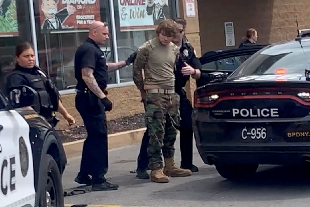 A man is detained following a mass shooting in the parking lot of TOPS supermarket, in a still image from a social media video in Buffalo