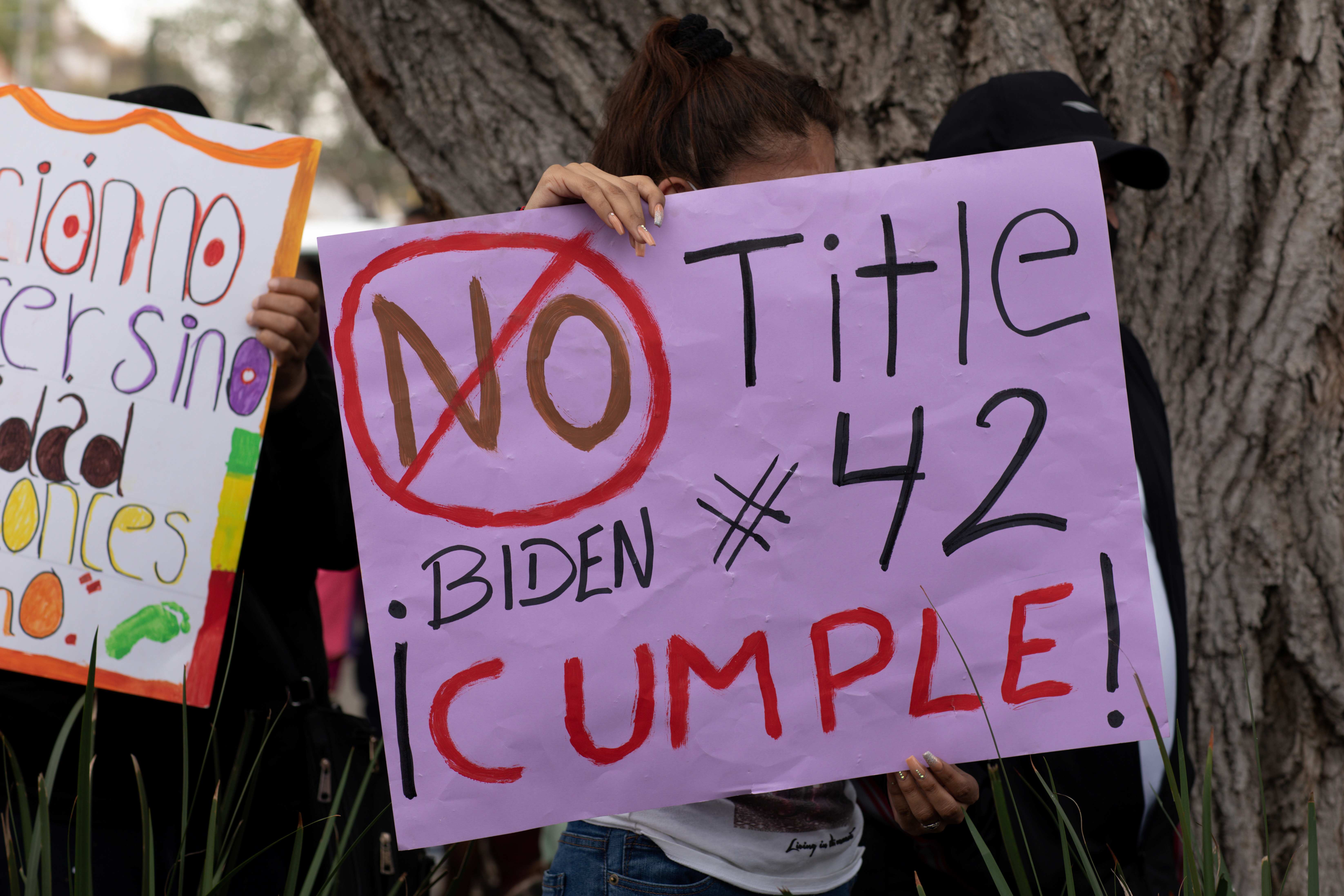 A woman holds a sign that reads “No Title 42 Biden Cumple” at a migrant-led protest against the U.S. Title 42 order, which prevents people from being able to seek asylum, held after the U.S. reopened land borders to vaccinated travelers for the first time since coronavirus disease (COVID-19) restrictions were imposed, in Nogales, Mexico November 8, 2021. Picture taken November 8, 2021. REUTERS/Caitlin O'Hara
