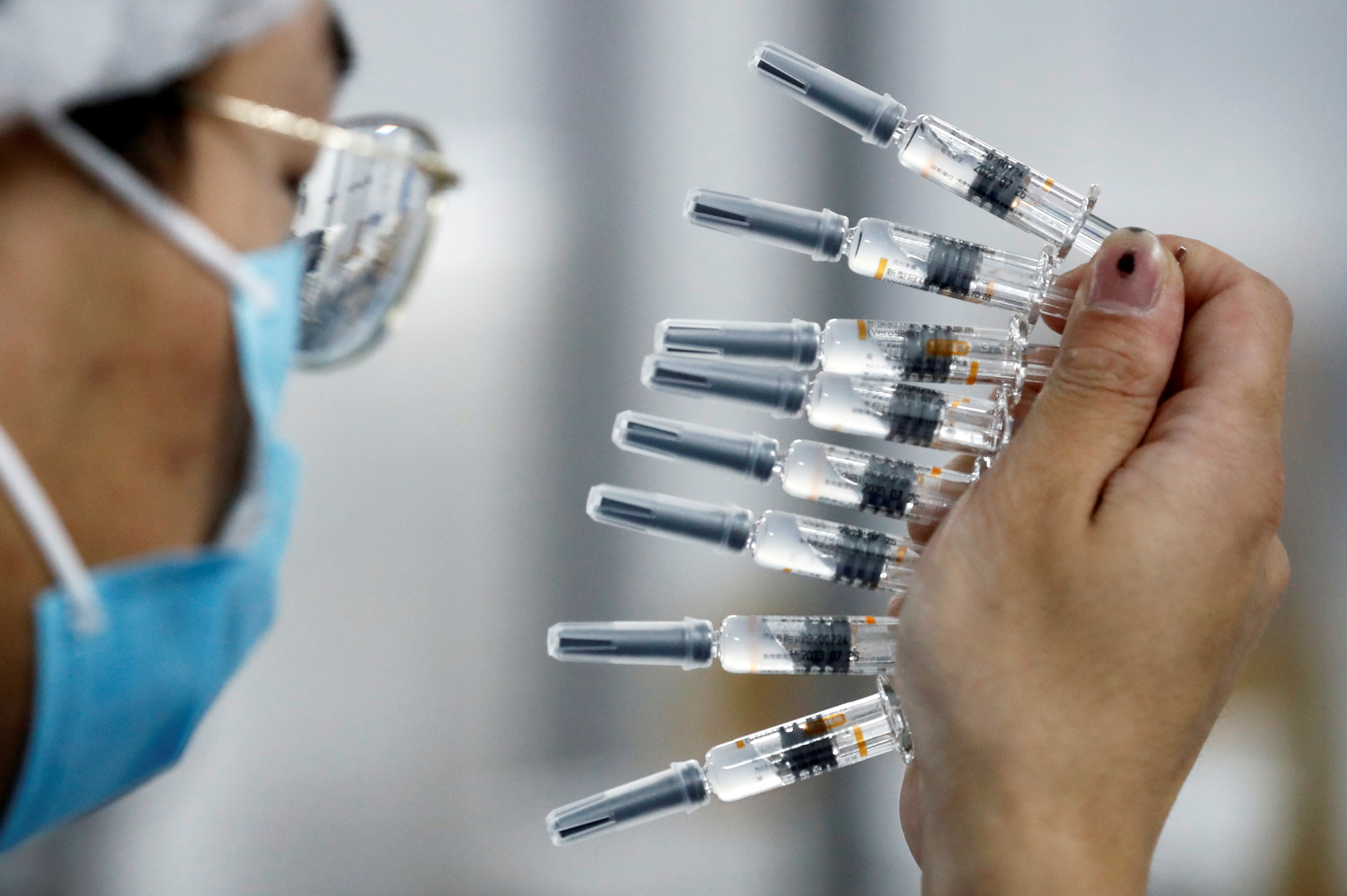 A worker performs a quality check in the packaging facility of Chinese vaccine maker Sinovac Biotech, developing an experimental coronavirus disease (COVID-19) vaccine, during a government-organized media tour in Beijing, China, September 24, 2020. REUTERS/Thomas Peter/File Photo