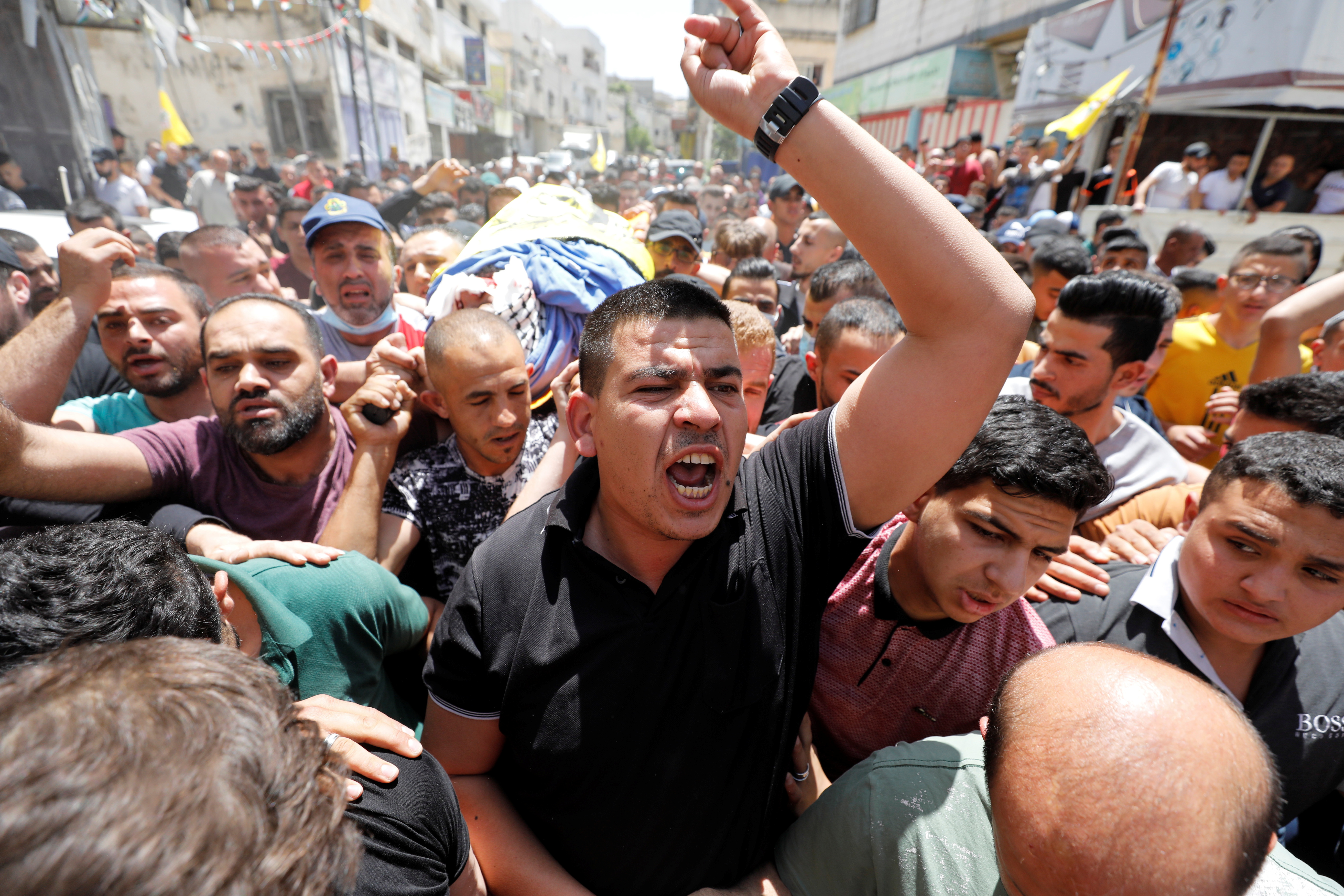 Death toll rises in Gaza and Israel in most intense hostilities in years 6 A mourner reacts as they carry the body of Palestinian man Hussien al-Titi, who was killed during stone-throwing clashes with Israeli forces, at Fawwar refugee camp near Hebron, in the Israeli-occupied West Bank, May 12, 2021. REUTERS/Mussa Qawasma