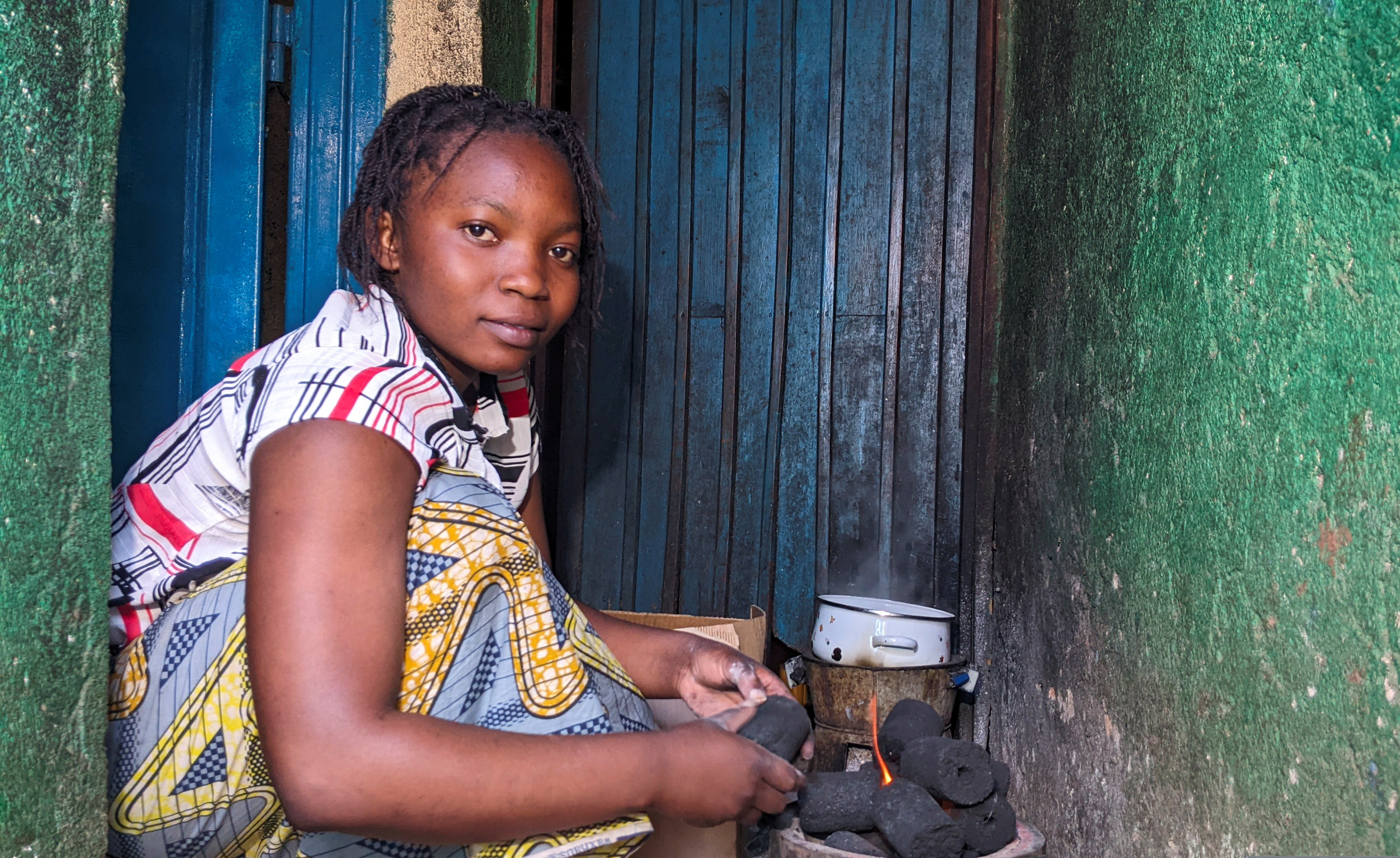 A woman lights an eco-friendly cooking charcoal stove in the Democratic Republic of Congo.