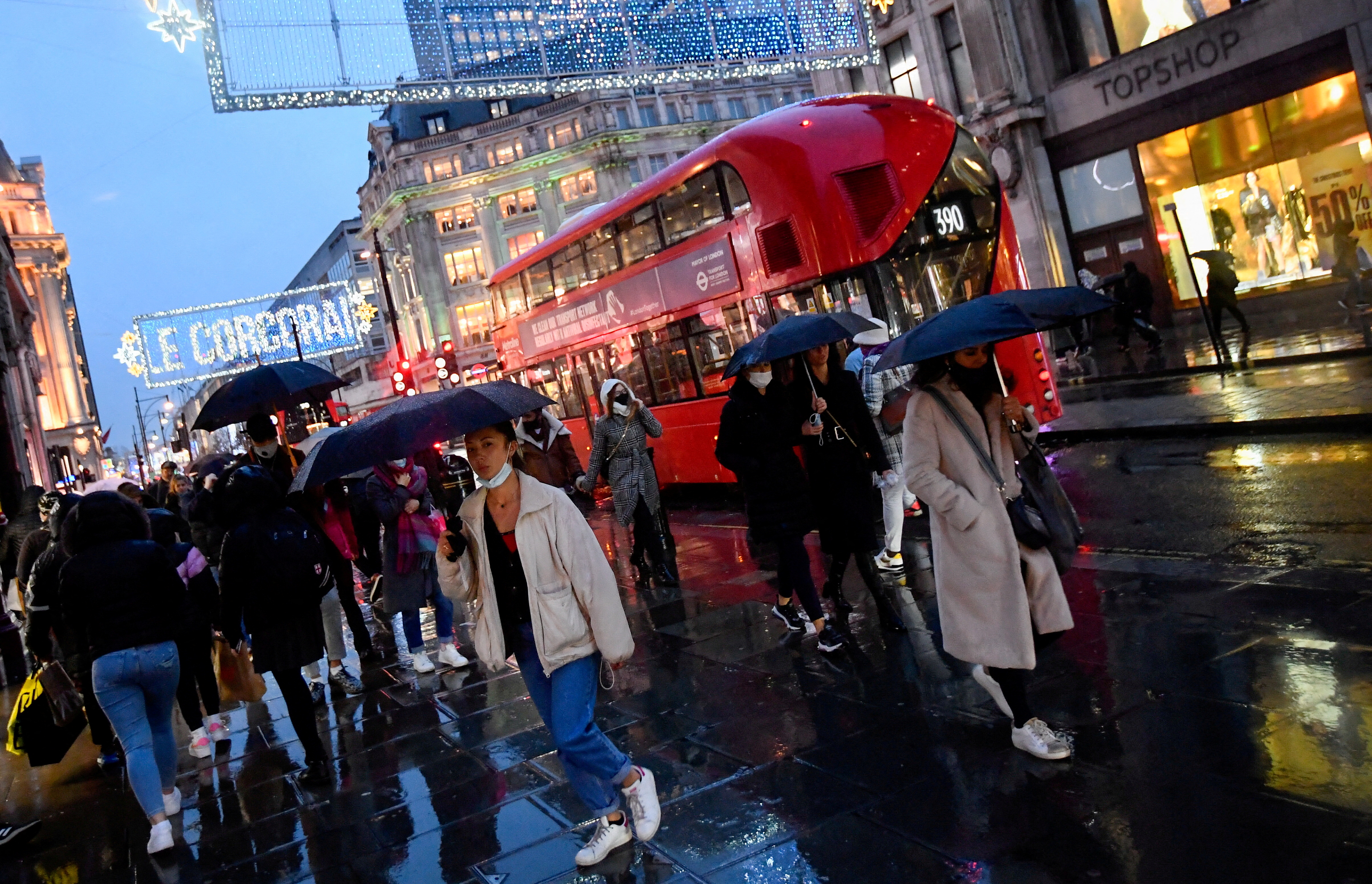 Shoppers hold umbrellas as they walk, following the outbreak of the coronavirus disease (COVID-19), at Oxford Street in London