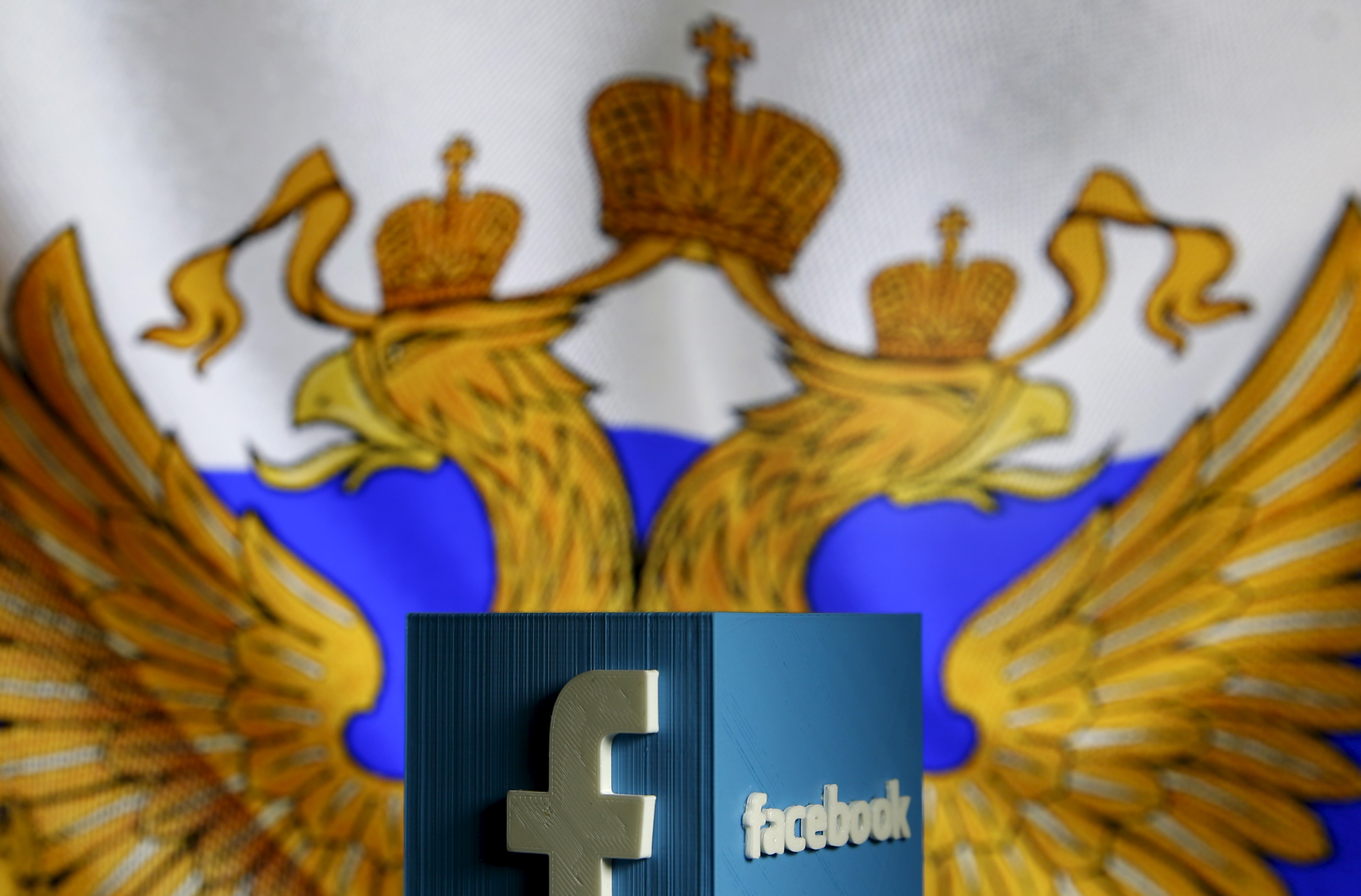 A 3D model of the Facebook logo is seen in front of a Russian flag in this photo illustration taken in Zenica