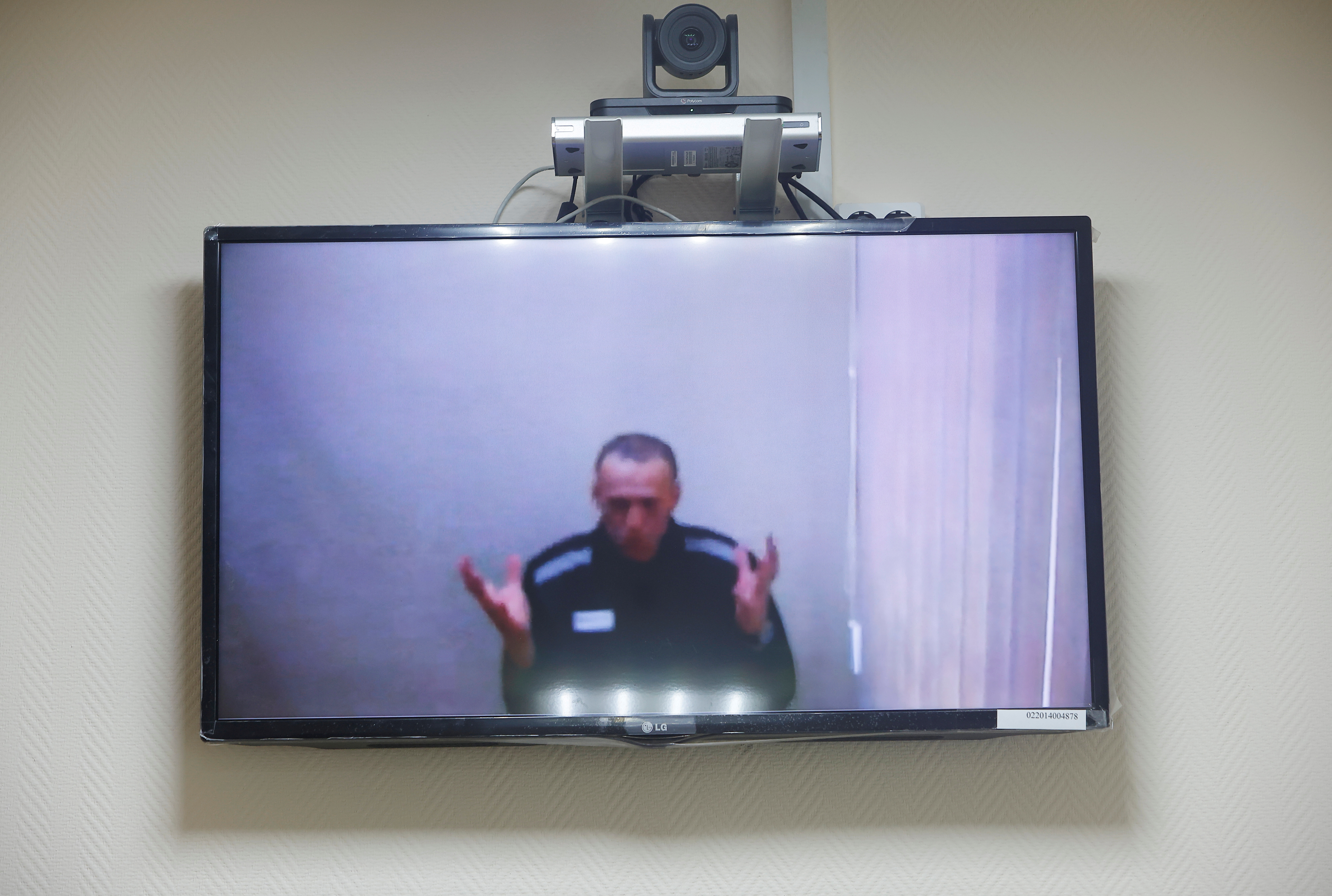 Russian opposition leader Alexei Navalny is seen on a screen via a video link during a hearing to consider his lawsuits against the penal colony over detention conditions there, at the Petushki district court in Petushki, Russia May 26, 2021. REUTERS/Maxim Shemetov