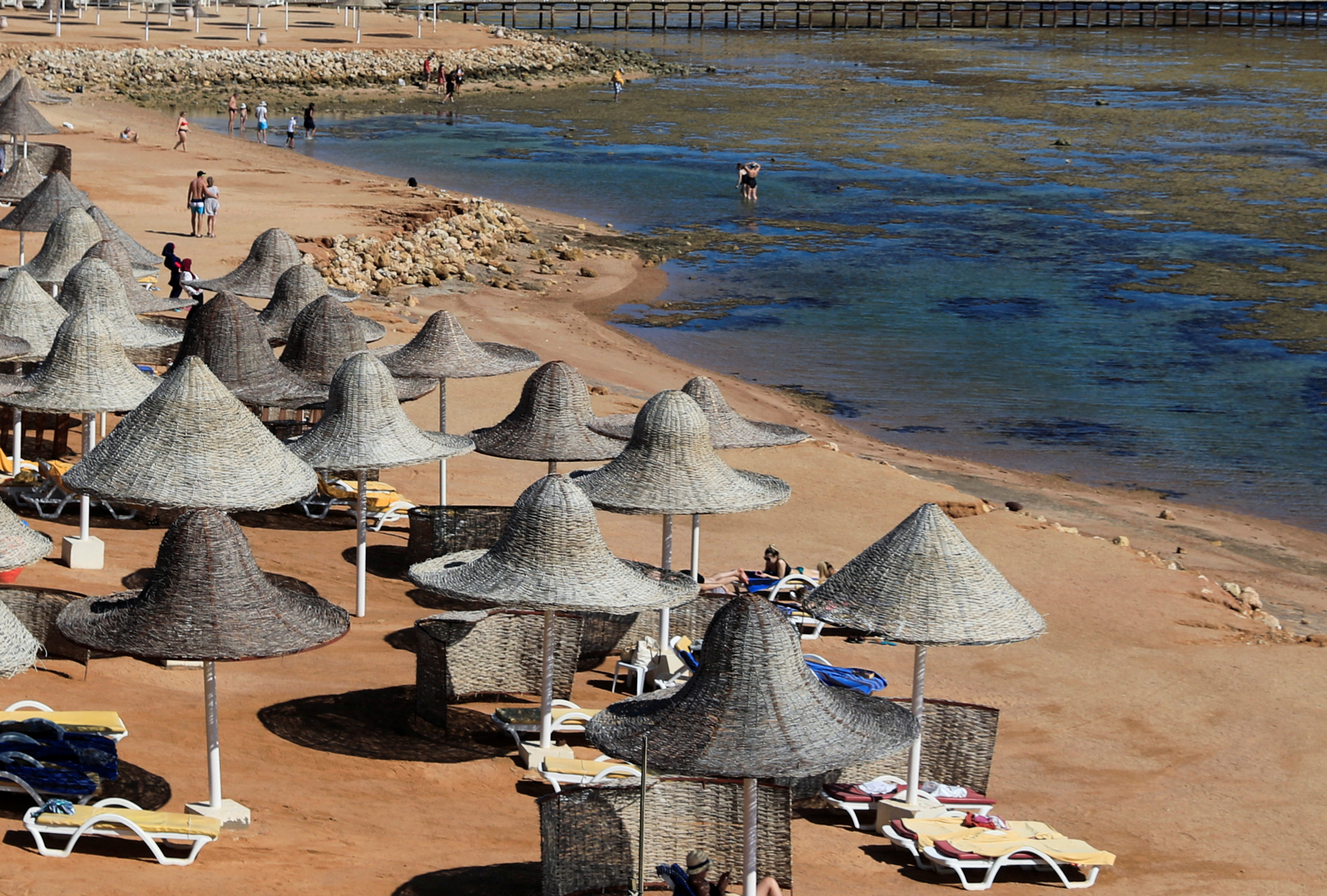 Tourists enjoy a day by the beach during a low tide in the Red Sea resort of Sharm el-Sheikh