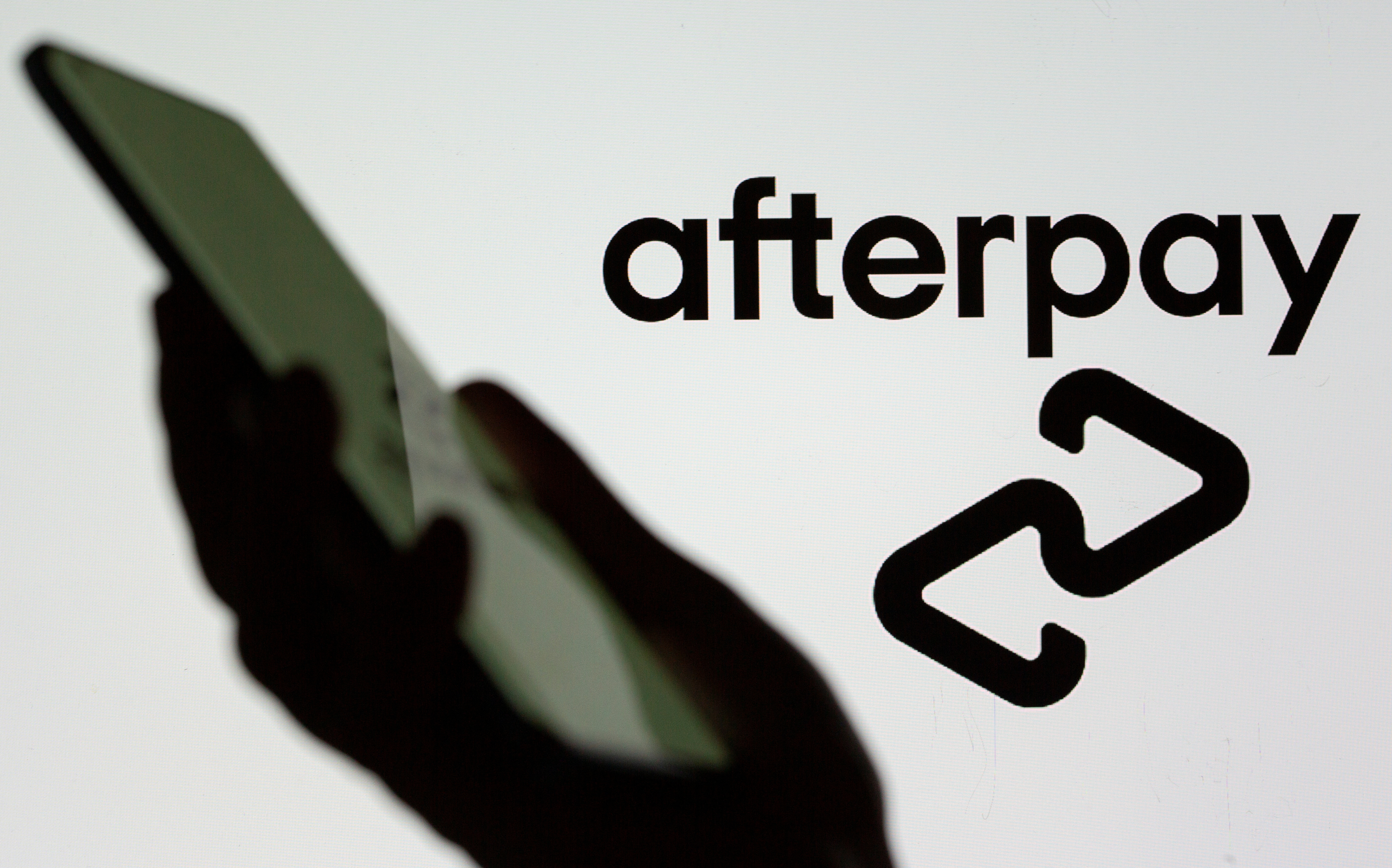 A smartphone is held in front of a displayed Afterpay logo in this illustration taken, August 2, 2021. REUTERS/Dado Ruvic/Illustration