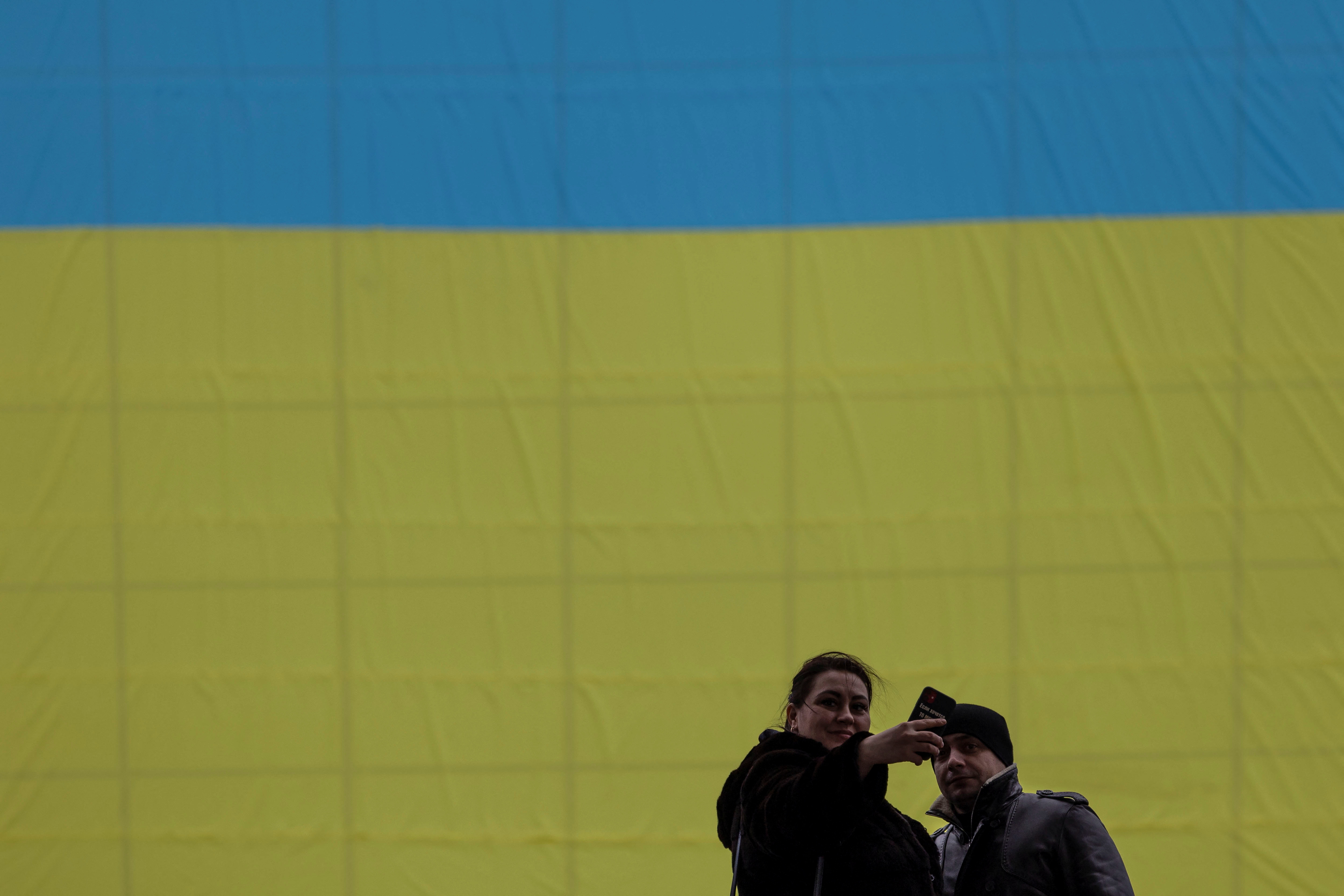 Residents take a selfie in front of a Ukrainian national flag during Unity Day holidays in Kyiv