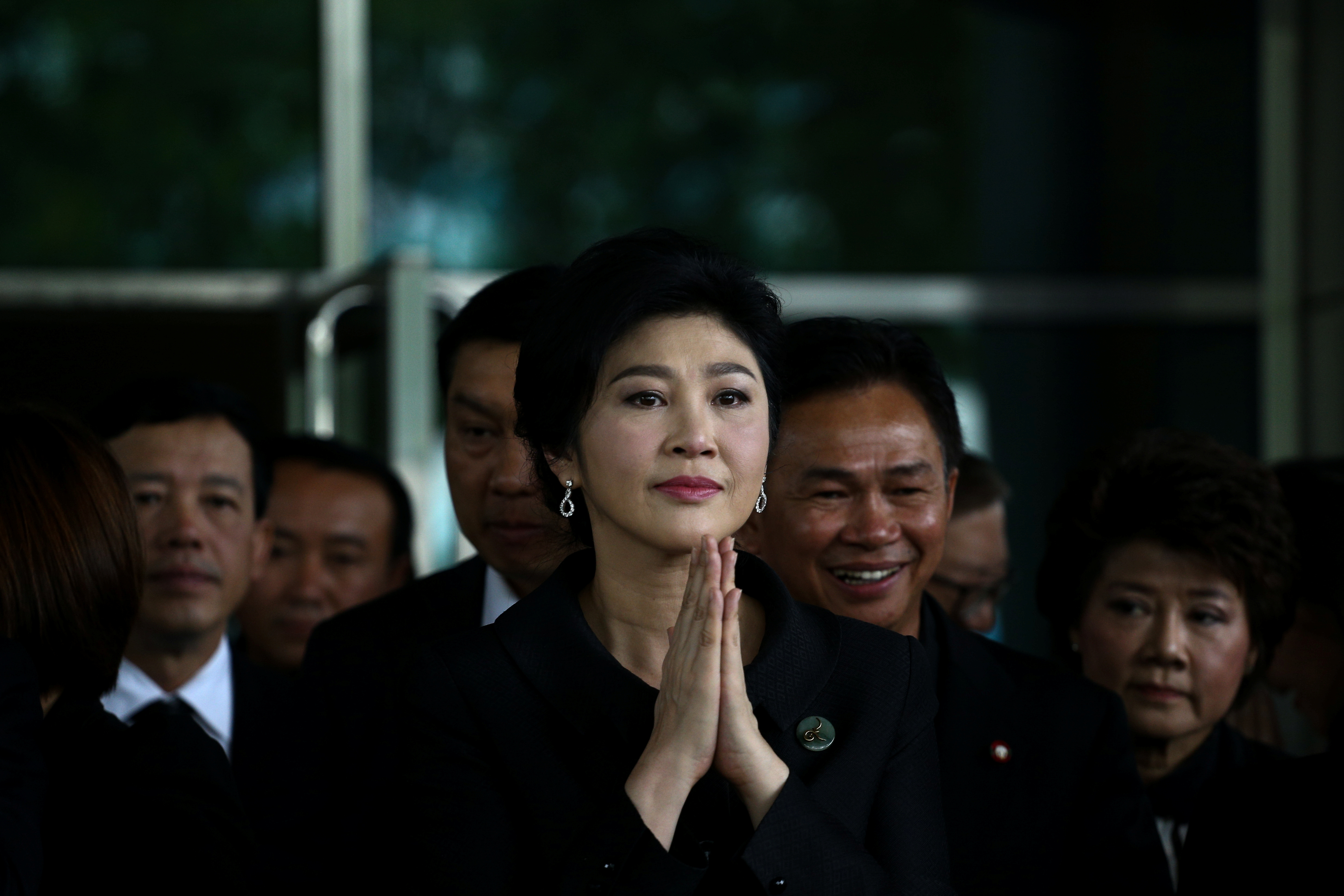 Ousted former Thai prime minister Yingluck Shinawatra greets supporters as she arrives at the Supreme Court in Bangkok