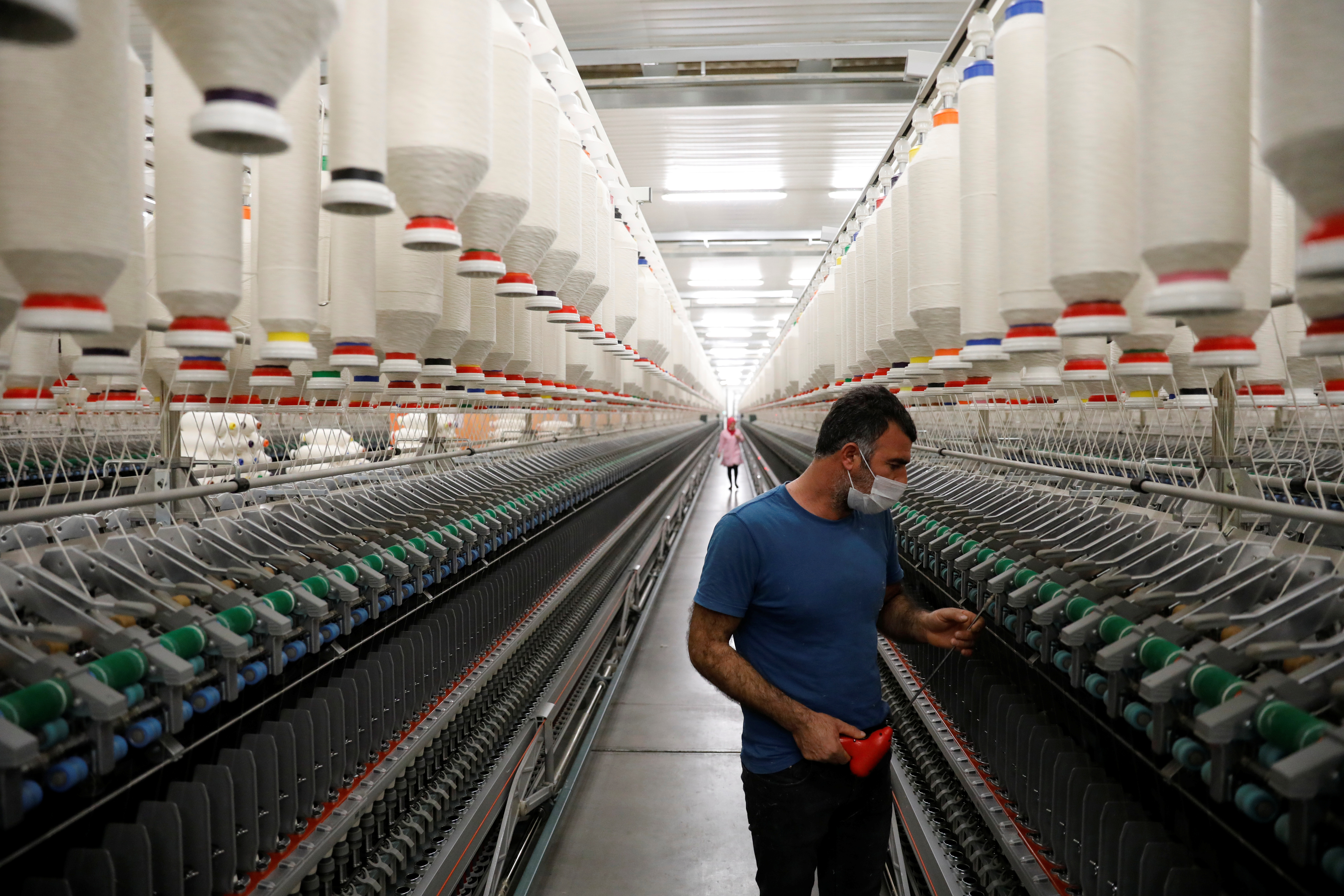 A worker makes a regular check on machines in a textile factory in Diyarbakir