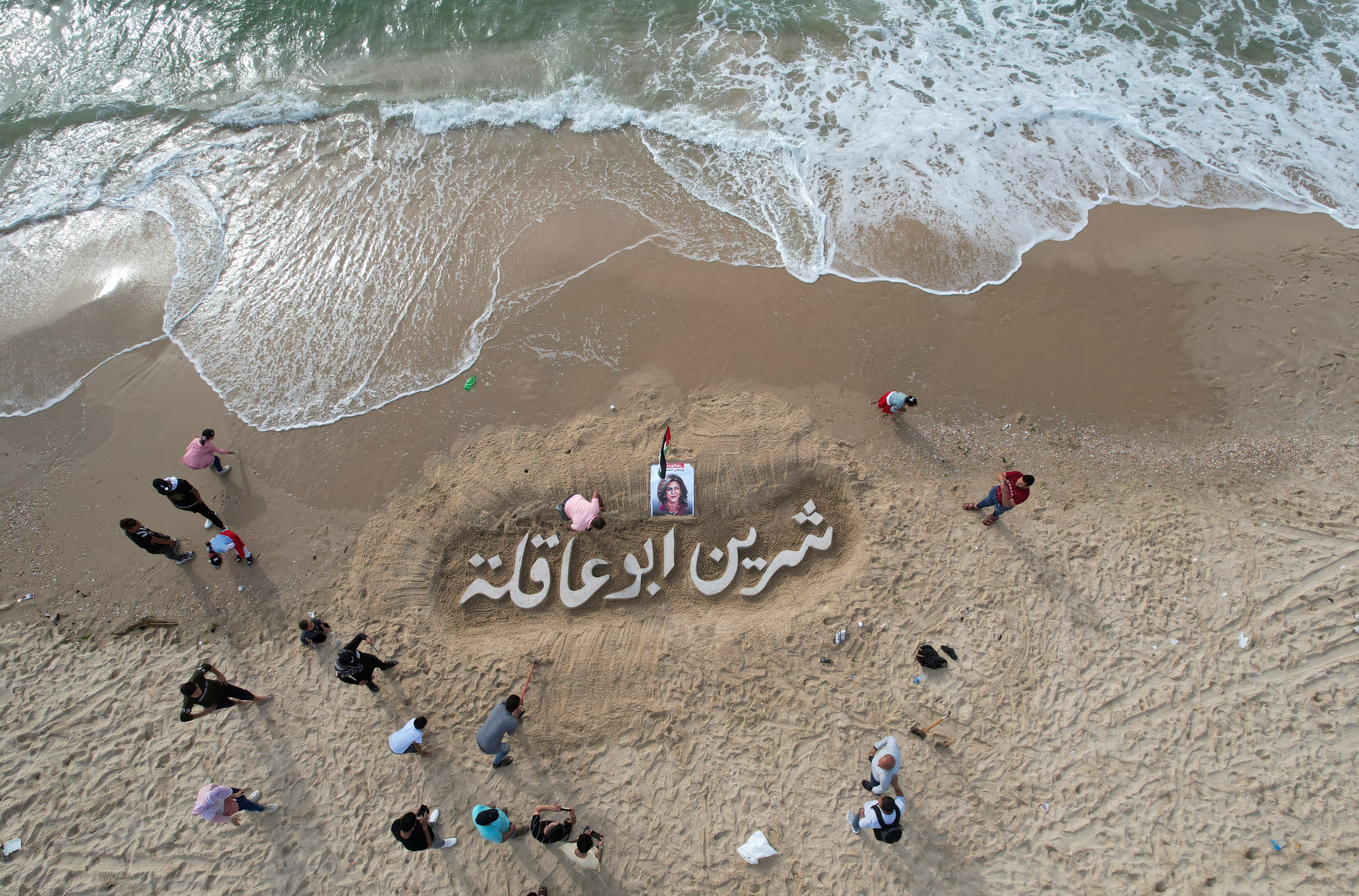 A sand sculpture reads "Shireen Abu Akleh", for the Al Jazeera reporter who was killed in an Israeli raid in the Israeli-occupied West Bank, on a beach in Gaza City